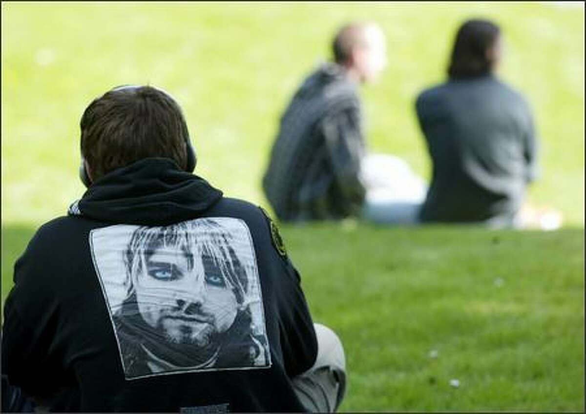 Justin Sevier wears a jacket with the image of Kurt Cobain on the back as helistens to a Nirvana tune through headphones at Viretta Park in Seattle.