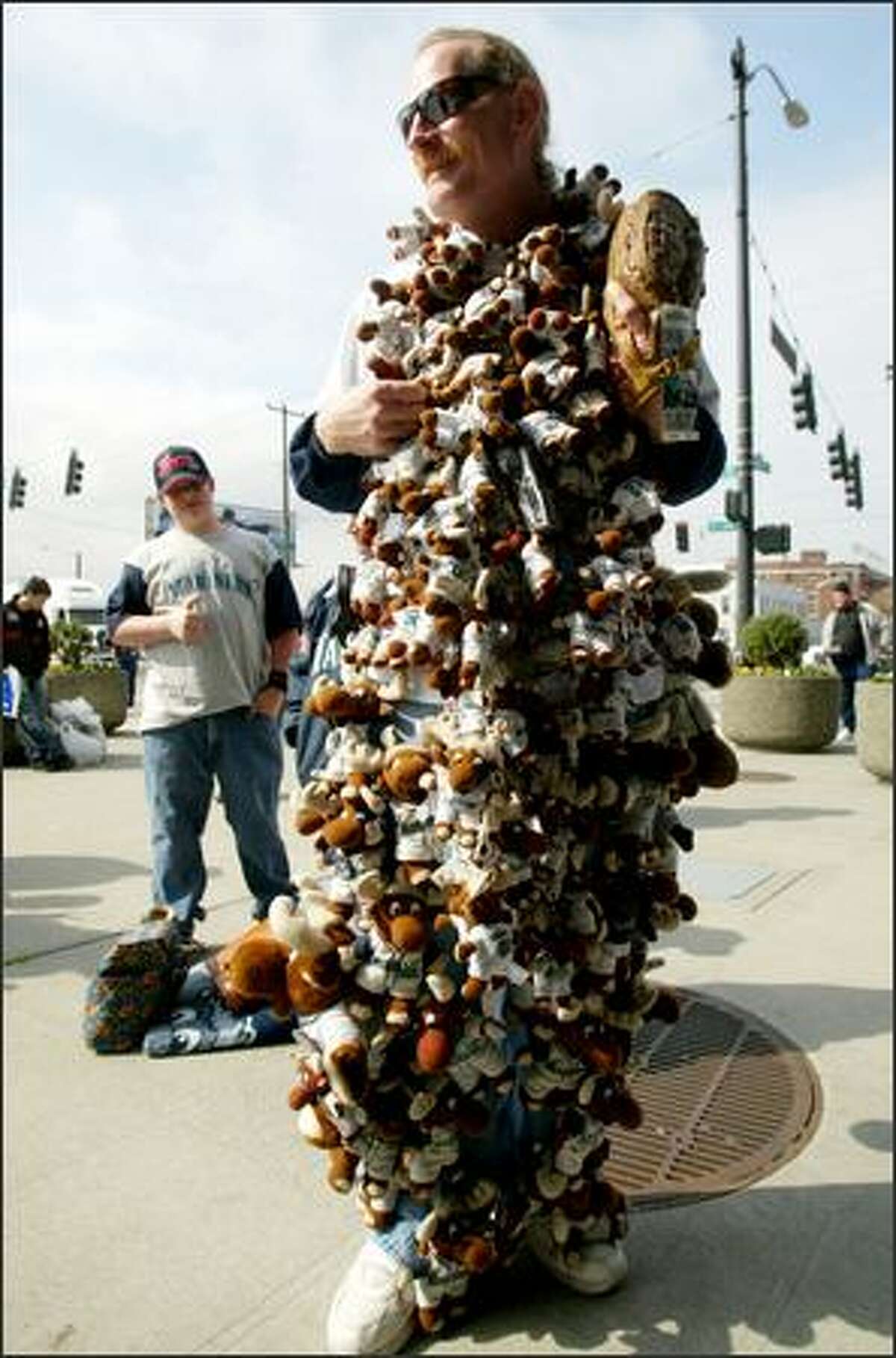 George "The Moose Man" King of Spanaway stands outside the ballpark covered in his "mojo tally" of 103 Mariner Moose dolls. King started collecting in 2000 and he buys a doll at each game he attends. If the M's win, he keeps the doll; if they lose, he finds a kid who is not having a happy day and presents it to the child.