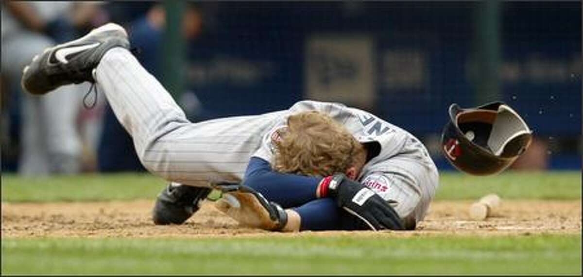 Minnesota's Justin Morneau hits the dirt after being struck in the head by Mariners reliever Ron Villone in the eighth inning.
