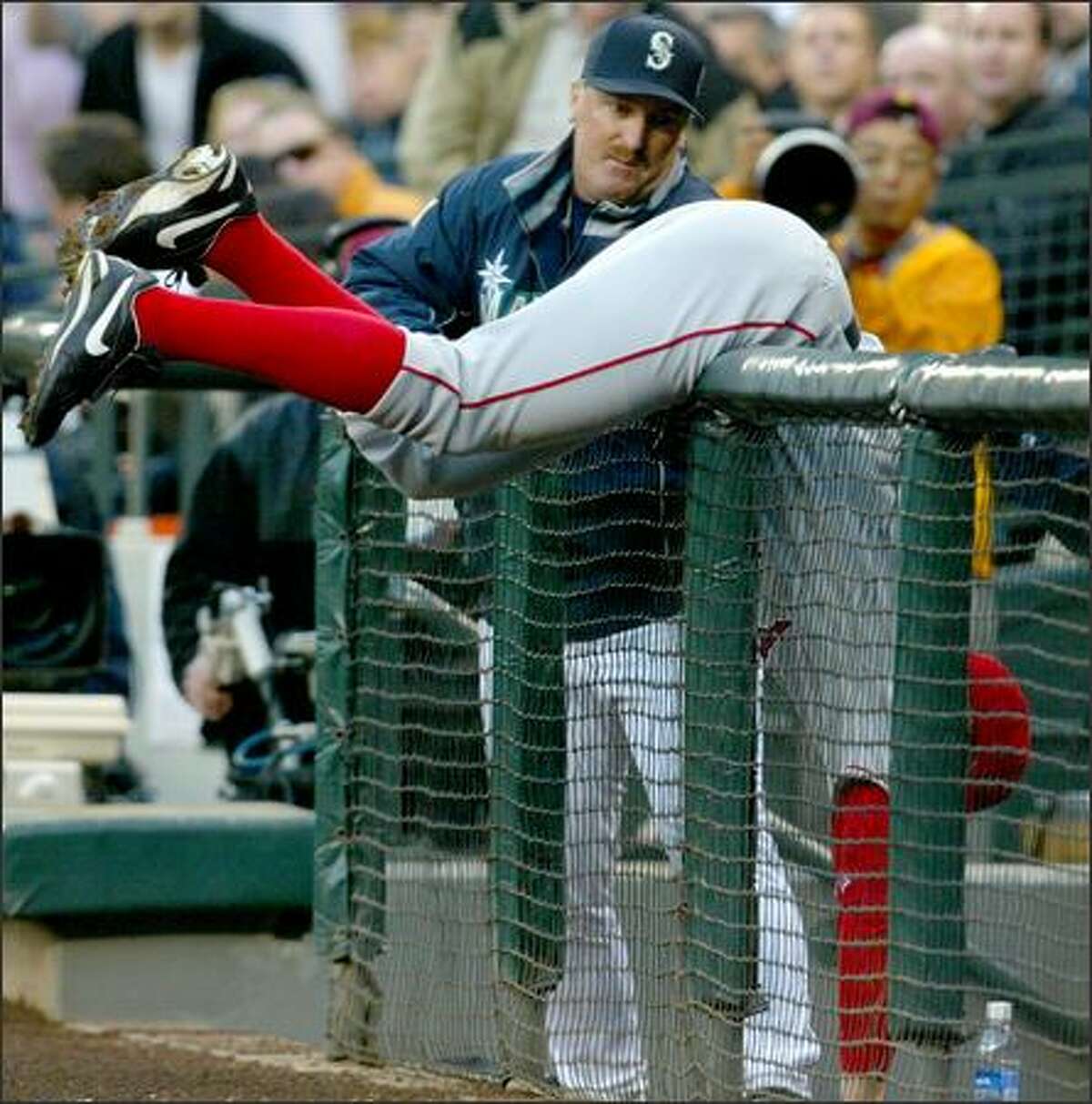 Angels first baseman Darin Erstad hangs over the railing protecting the Mariners dugout as he fails to catch a Bret Boone foul popup.