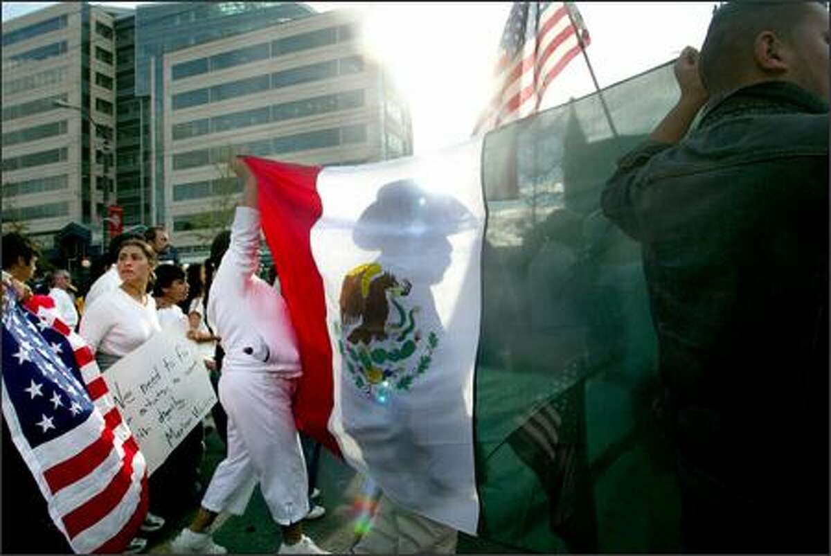 Thousands flooded Seattle streets during a large immigrant-rights march on Monday. Here, demonstrators move along King Street in the International District bearing a large Mexican flag amid U.S. flags.