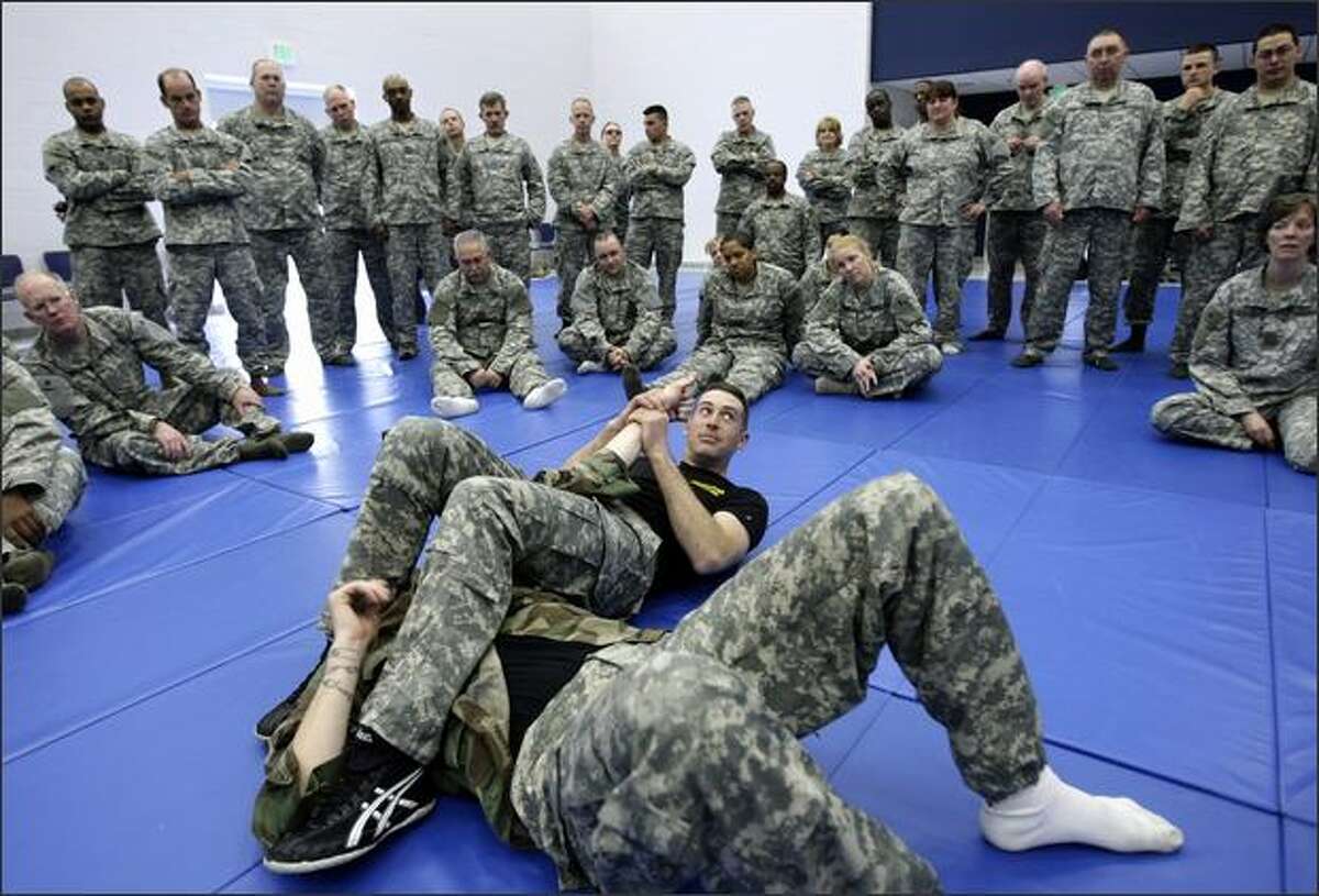 Sgt. First Class Bryan Pulak, with the 191st Infantry Brigade out of Fort Lewis, demonstrates a move to break his opponent's arm to a group of soldiers with the 70th Regional Readiness Command at Fort Lawton.