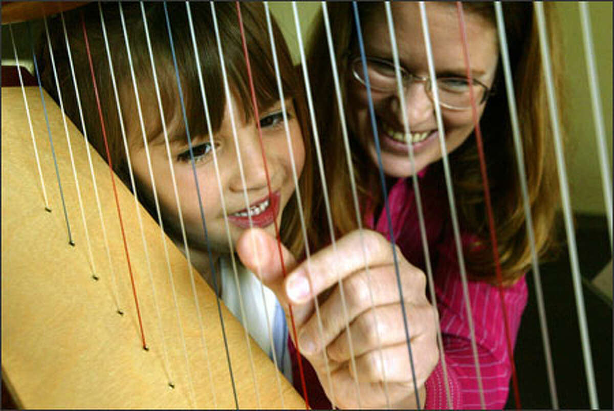 Megan Morrell, 6, watches her instructor, harpist Juliet Stratton, demonstrate proper thumb positioning at the Washington Academy of Performing Arts in Redmond. Megan is learning to perform "Air" from Franz Joseph Haydn's "Surprise" Symphony, No. 94, in preparation for her class' May recital. Through the academy's open program, classes are available to students of almost any age.