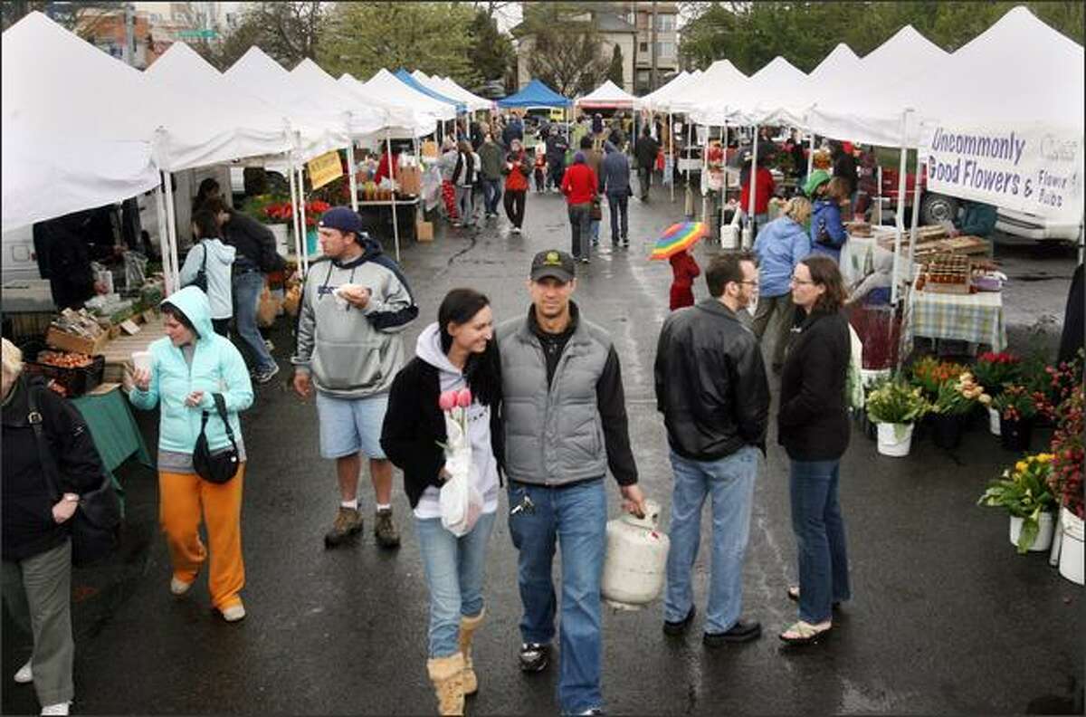 Shoppers turned out at the University District Farmers Market in Seattle despited the cold weather and rain on Saturday.
