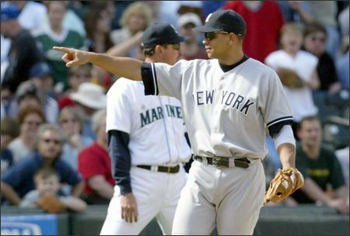 After catching Ichiro Suzuki's line drive to end the game, Alex Rodriguez (2-for-3, HR) points to manager Joe Torre, who had moved the third baseman closer to the line before the play.
