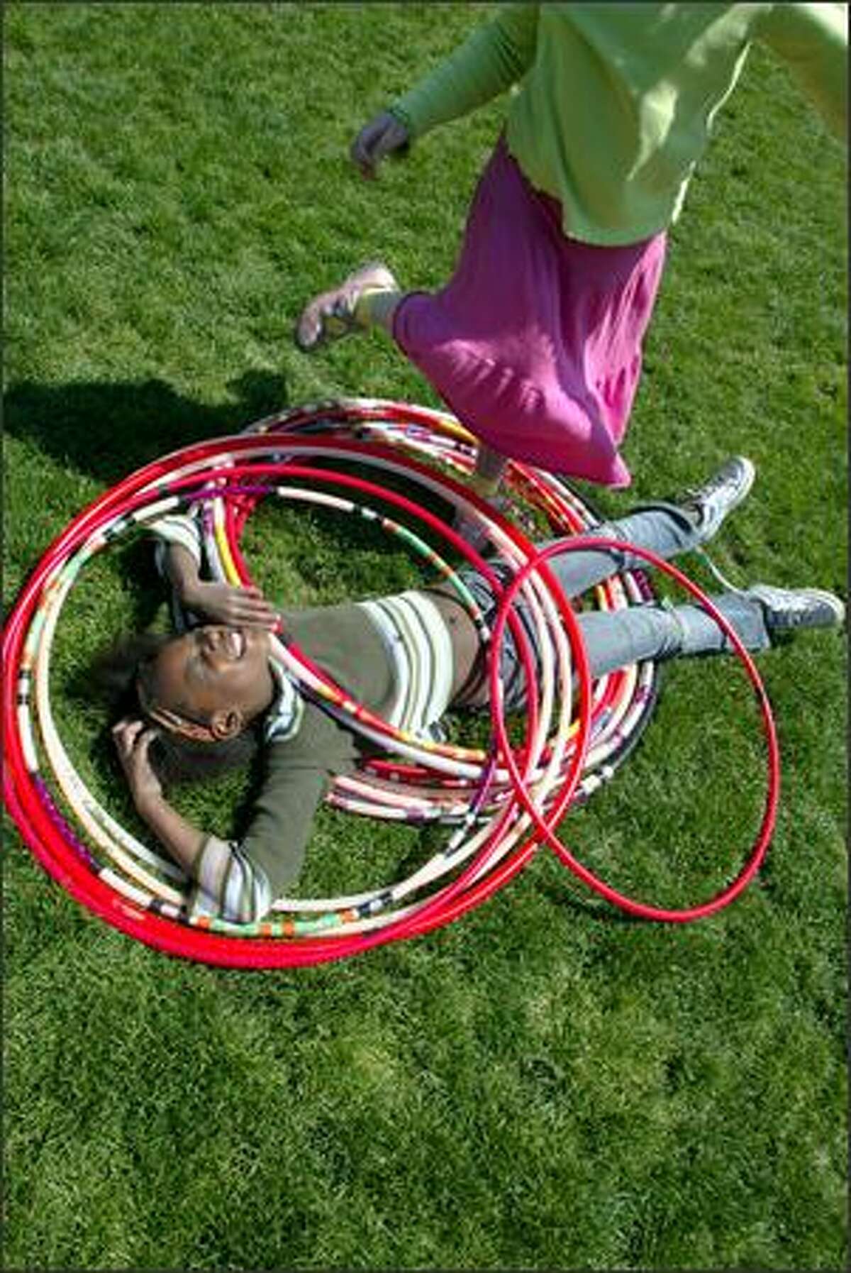Nkechi Ogugua takes a break among the hula hoops as her friend Isabella Geist plays with them during the Seattle International Children's Festival at the Seattle Center. Both 8-year-olds are students at Daniel Bagley Elementary School. The festival runs through Saturday. For information: www.seattleinternational.org