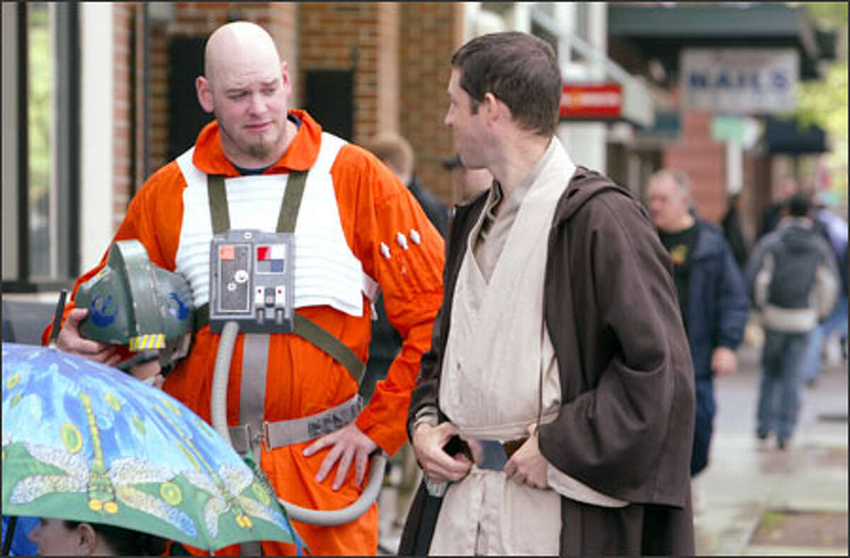 "Star Wars" fans Jason Burrows, left, dressed as an X-wing pilot, and Jedi Knight Greg Evans line up on Fifth Avenue in Seattle in anticipation of the midnight showing of "Star Wars: Episode III -- Revenge of the Sith."