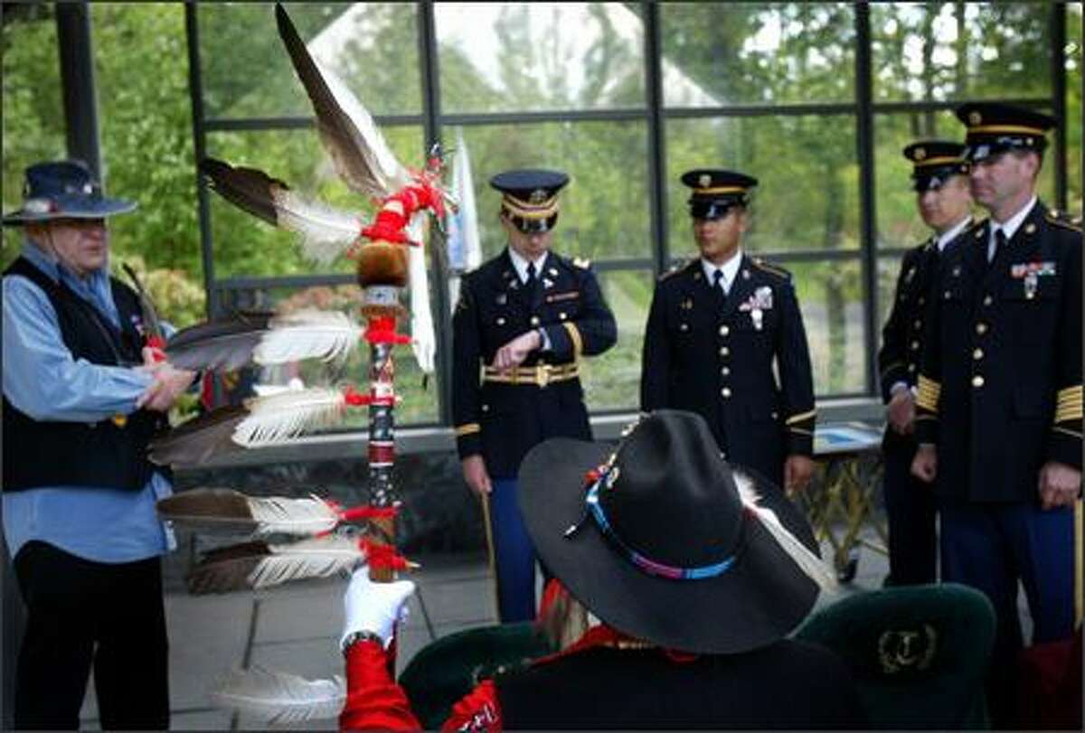 Nisqually Tribal member Robert Sison, holding eagle feather staff, waits with members of the Army National Guard from Camp Murray and fellow Inter-Tribal Honor Guard member Warren Gohl for a military funeral on May 17 at Tahoma National Cemetery. The Inter-Tribal Honor Guard performs military honors for funerals and other military- and veteran-related events.