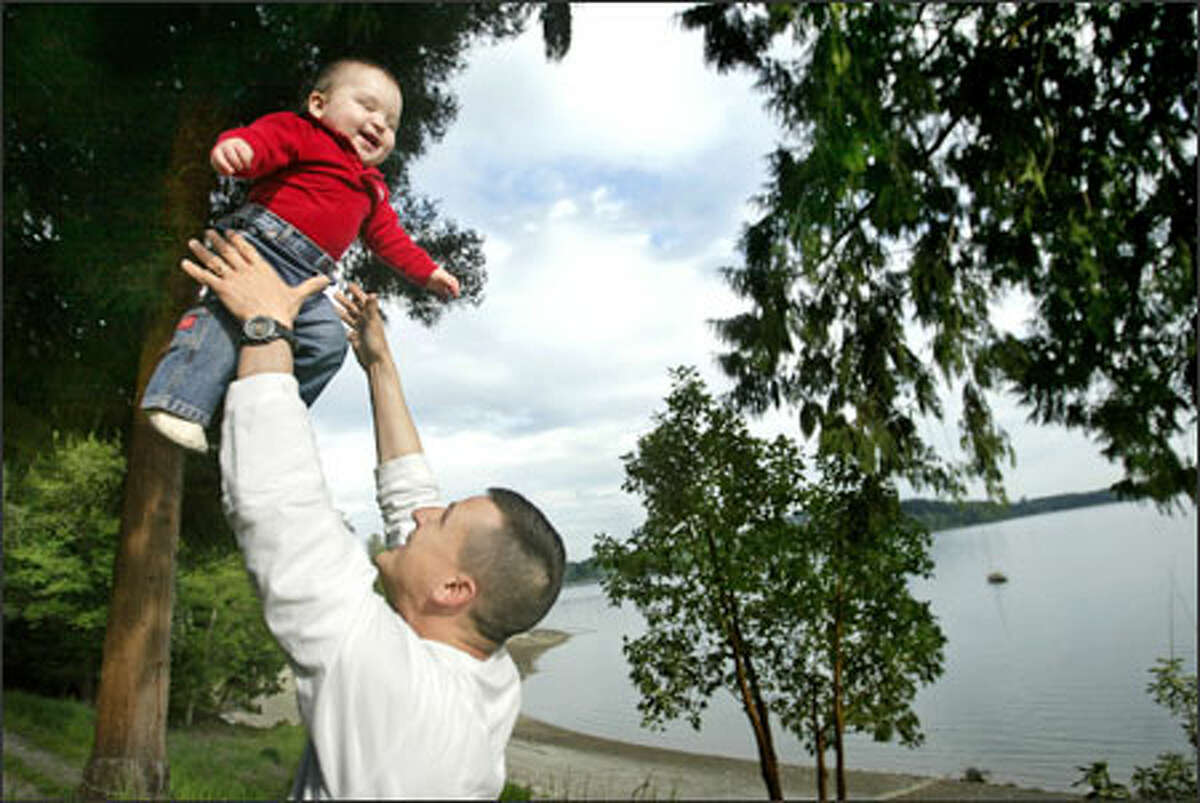 Back from Iraq, Lt. John Adams of the Washington National Guard plays with his son, Ian, on their property in Shelton, where Adams operates a shellfish farm with his father. Adams' deployment, compounded by a medical emergency, put a strain on the family's shellfish business.