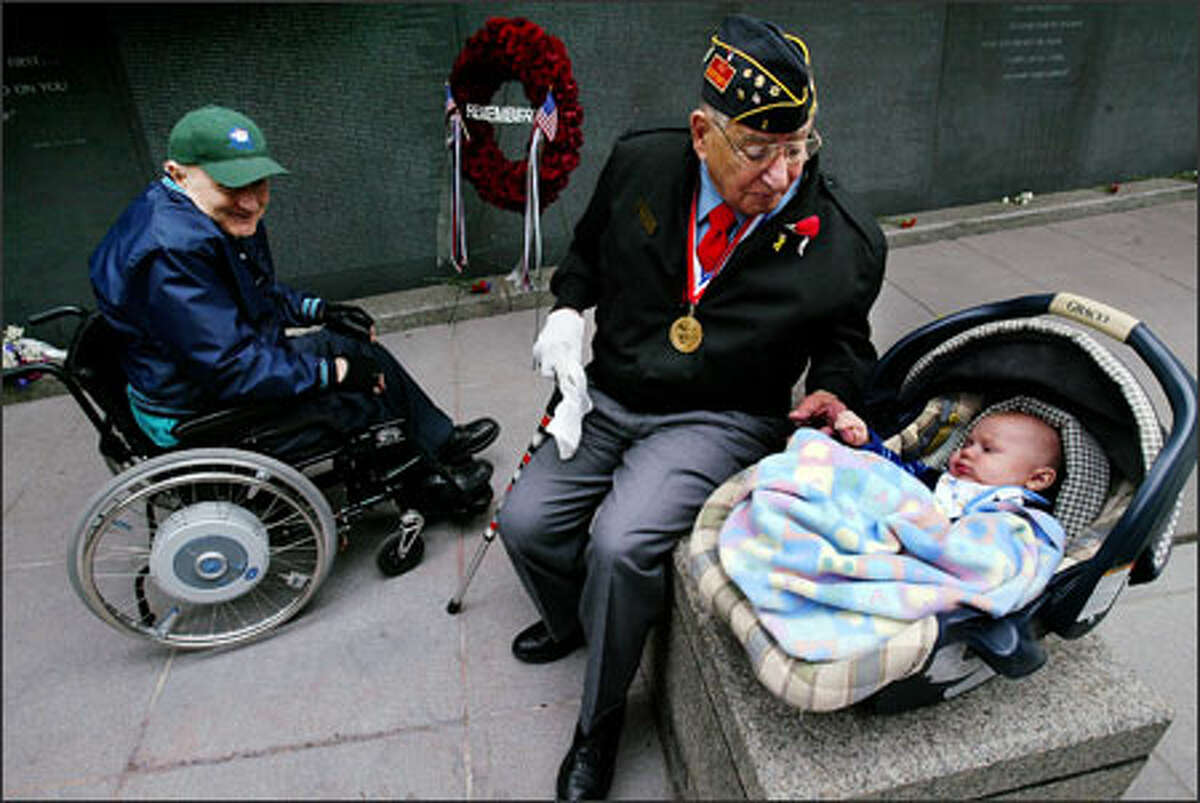 World War II veteran Joe Feldman makes friends with 3-month-old Nathan Lowe, while Vietnam veteran Jack Michaels watches at a Memorial Day service by the Garden of Remembrance wall at Benaroya Hall in Seattle. Nathan was named after his Marine father's friend, Lance Cpl. Nathan Wood, who was killed in Iraq in November. Wood's name was among those added to the wall.