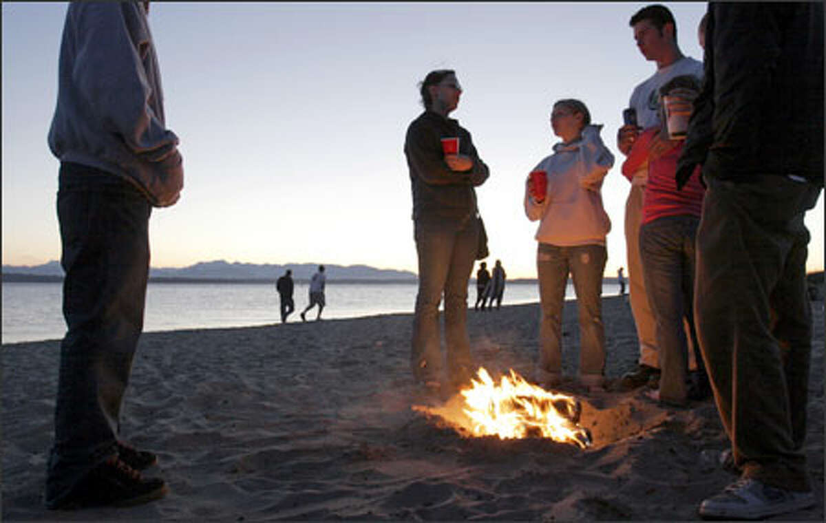 Young visitors to Golden Gardens Beach burn Duraflame logs in an illegal fire pit. People who build bonfires outside the designated fire rings cause a headache for parks officials and often leave a mess for maintenance workers to clean up. Golden Gardens Beach currently has 12 fire rings for bonfires, which are available on a first-come, first-served basis.