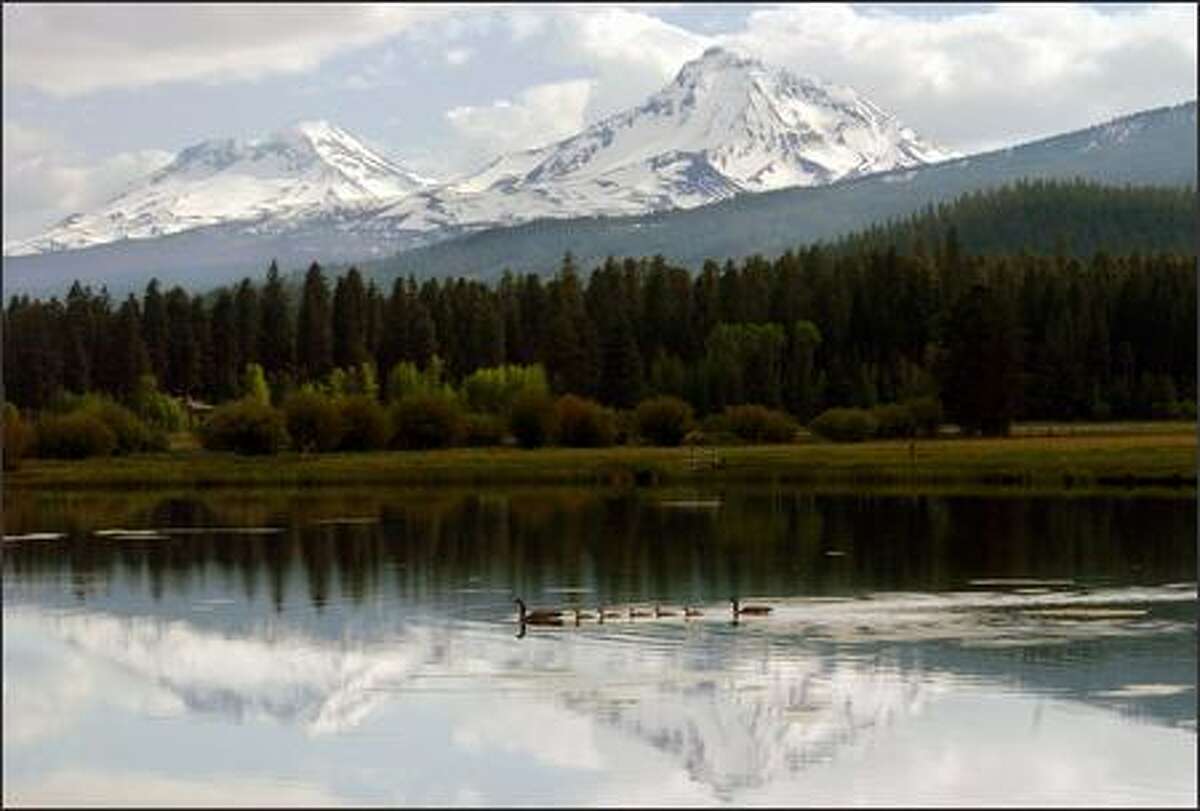 A fishing lake at the Black Butte Resort near Sisters, Ore., reflects two of the Three Sisters peaks, once known as Faith, Hope and Charity.