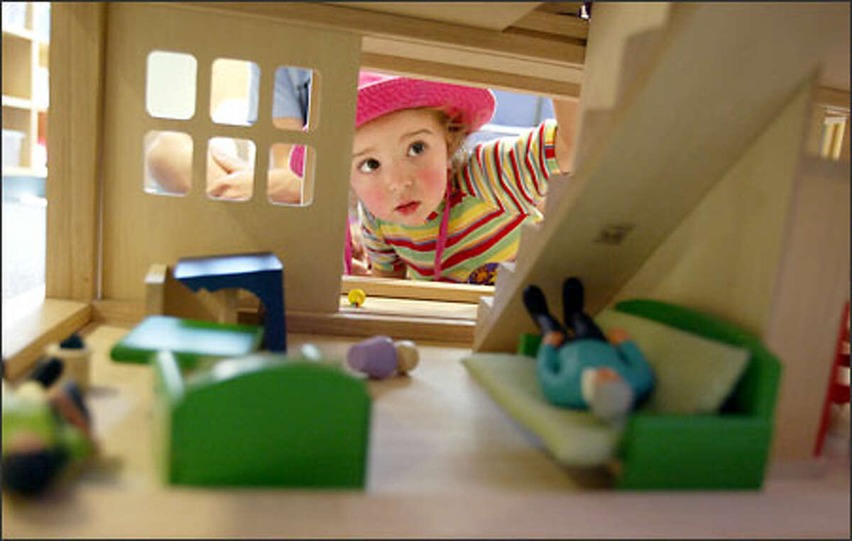 Eleanor Home, 2, of Tacoma checks out a dollhouse in the new play area at Mary Bridge Children's Hospital. Eleanor's newborn sister is at the hospital.