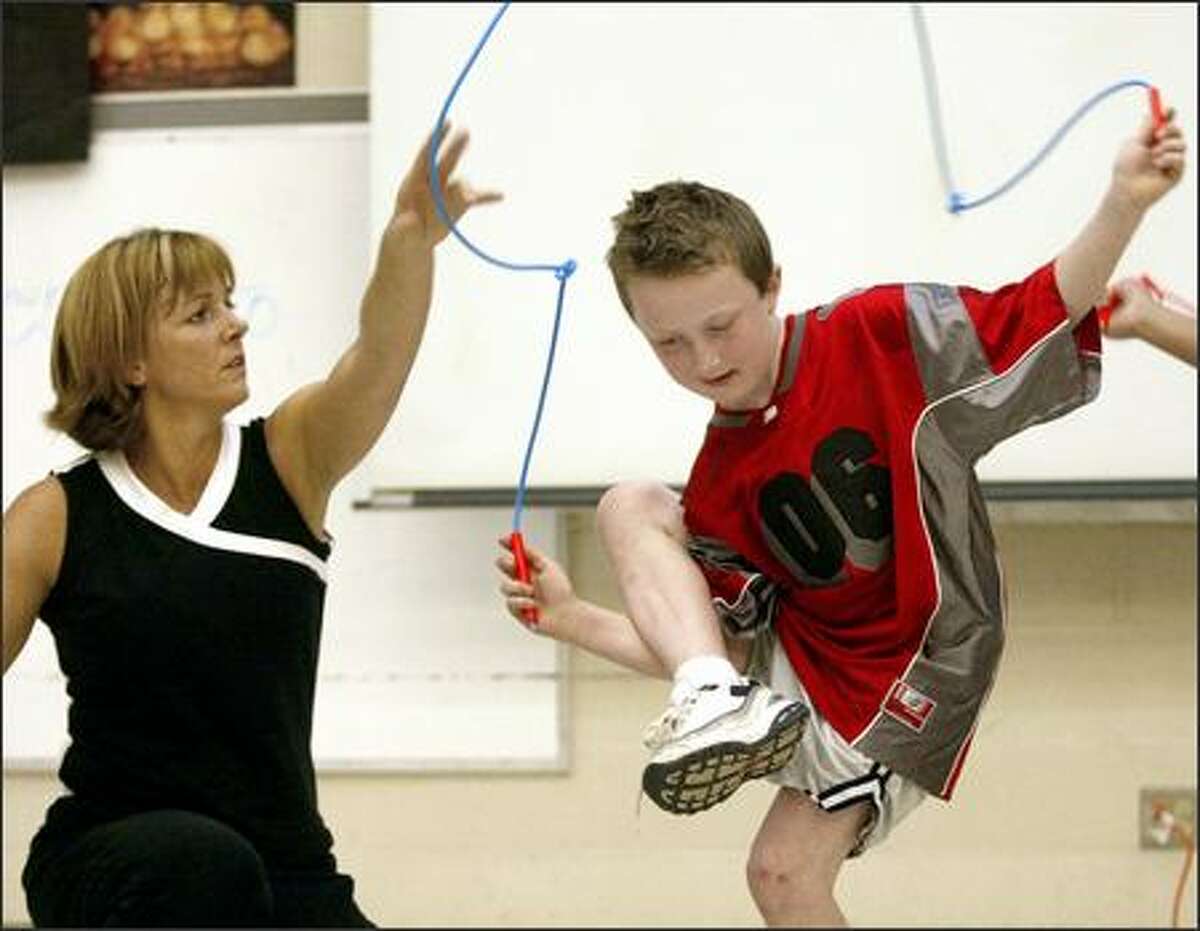 Rene Bibaud helps second-grader Stephen Fry do the "pretzel" during a jump rope demonstration at Cherry Crest Elementary in Bellevue.