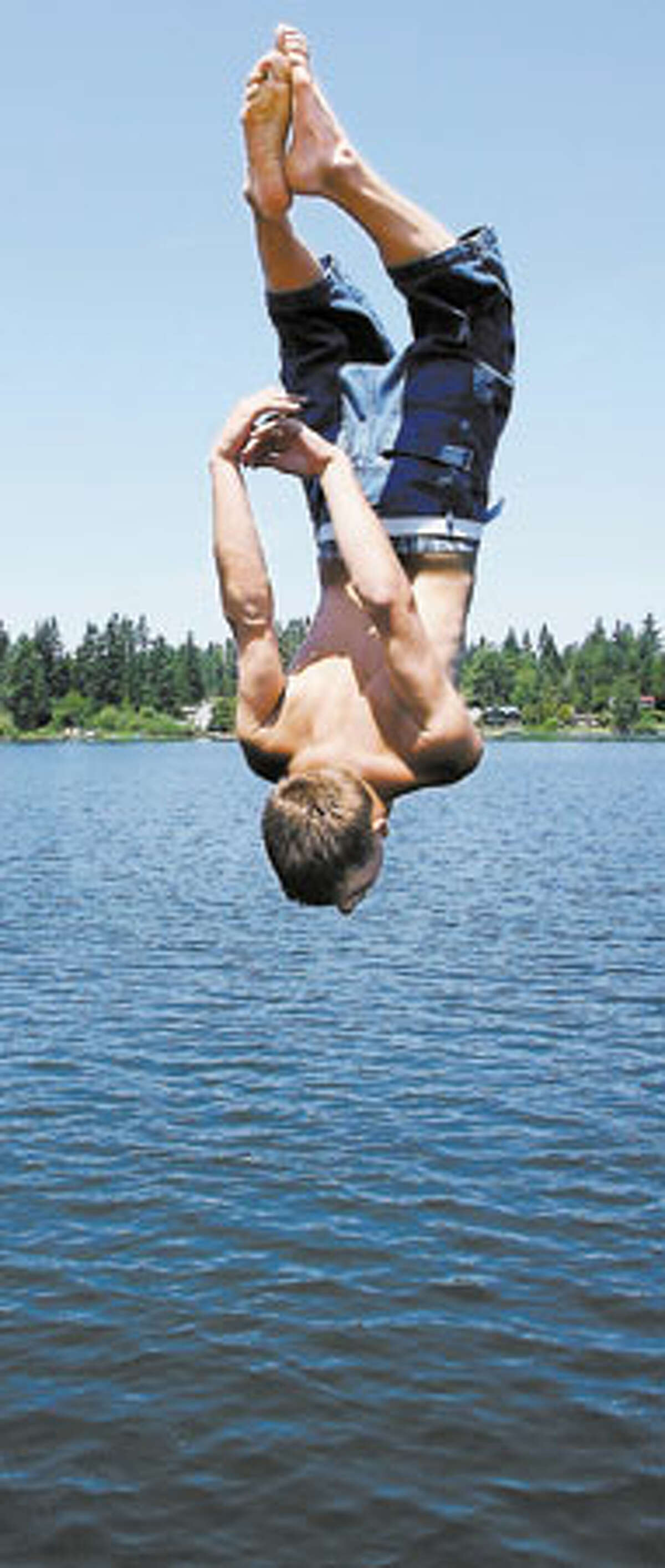 Cliff Swanson, 17, of Marysville does a back flip off the railing of the dock at Martha Lake Park in Mill Creek.