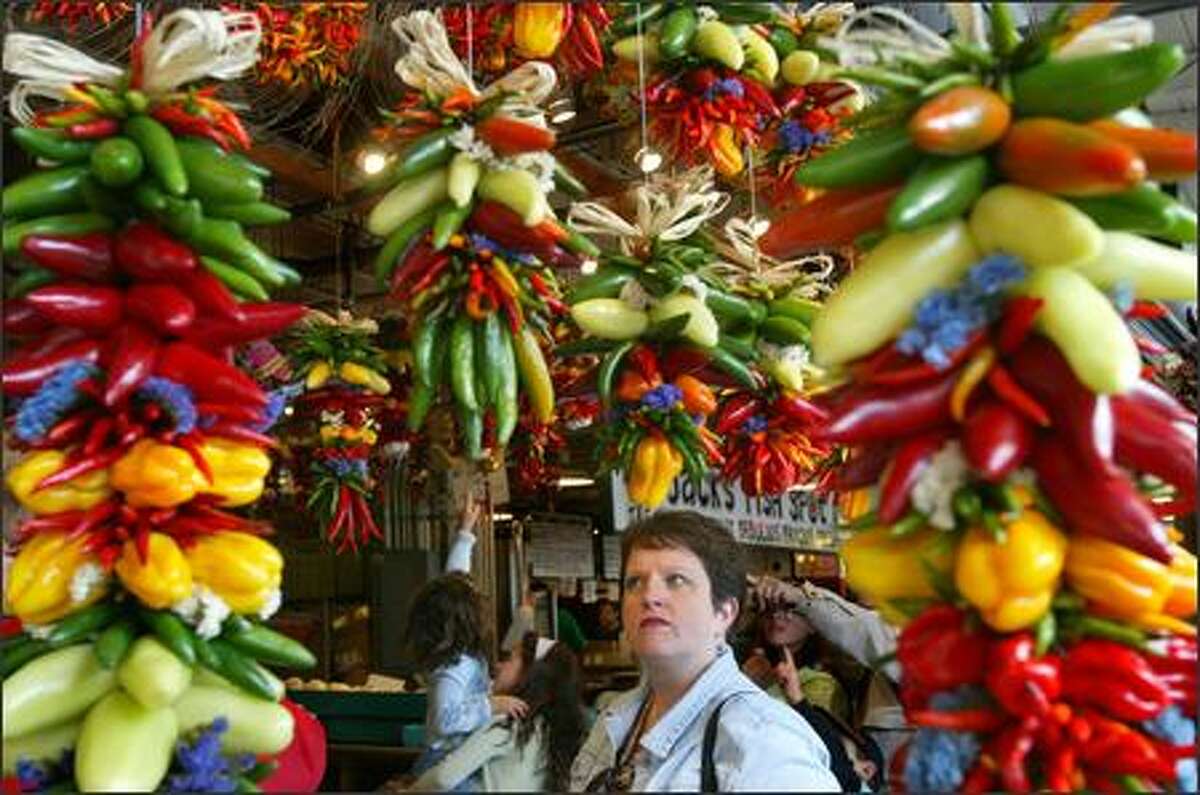 Janet Story, of Redmond, eyes the colorful chile ristras while her visiting mother purchases one at Choice Produce and Pepper at the Pike Place Market on June 15.