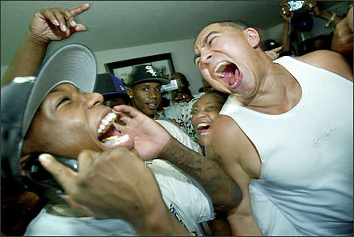 Nate Robinson, left, learns of his draft-day trade in a call from agent Eric Goodwin while celebrating his first-round selection with family and friends, including Herb Hartso, right.