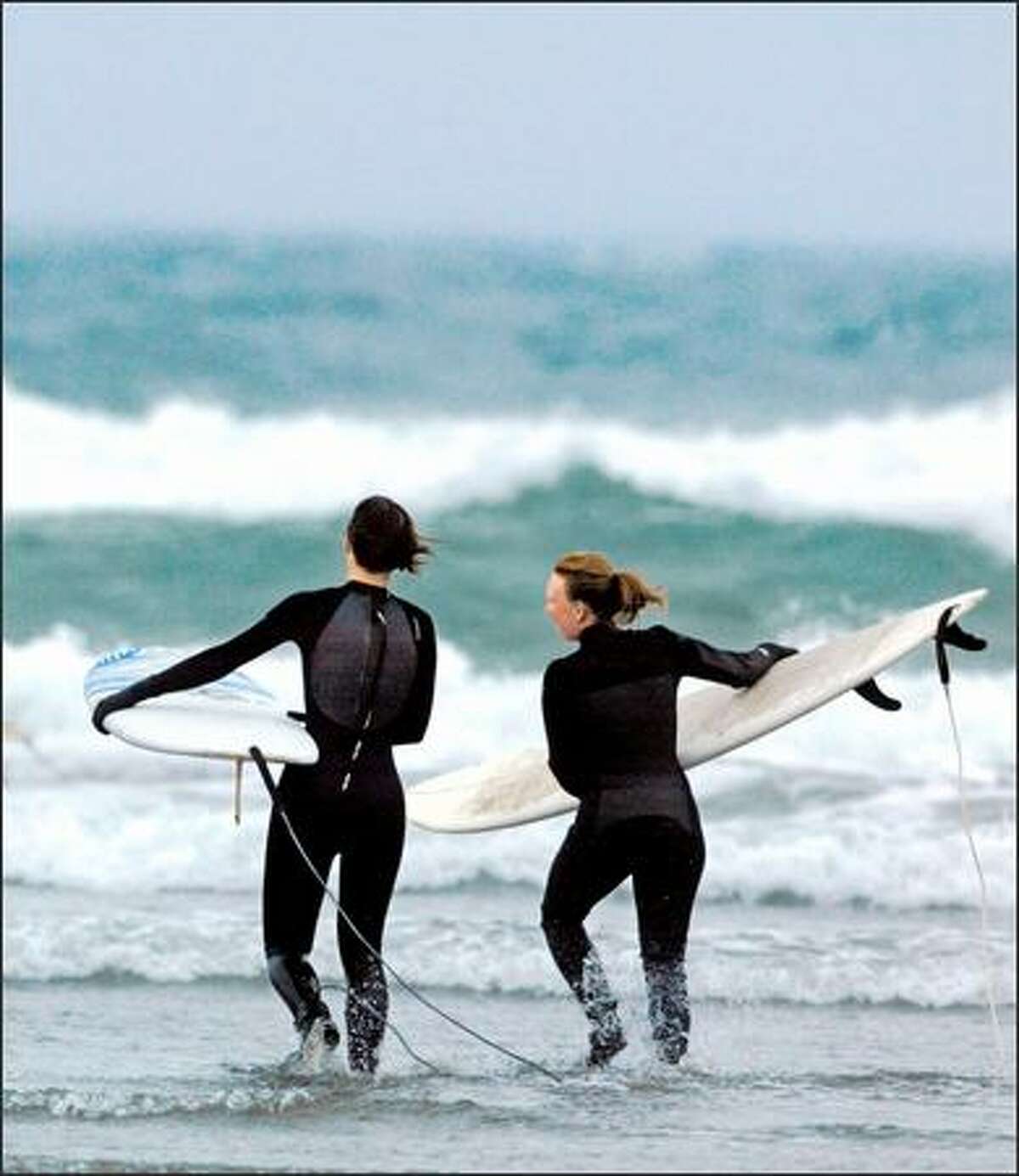 Andrea Platt, left, and Kristi Park, both fromm Seattle, head to the surf at Westhaven State Park in Westport.