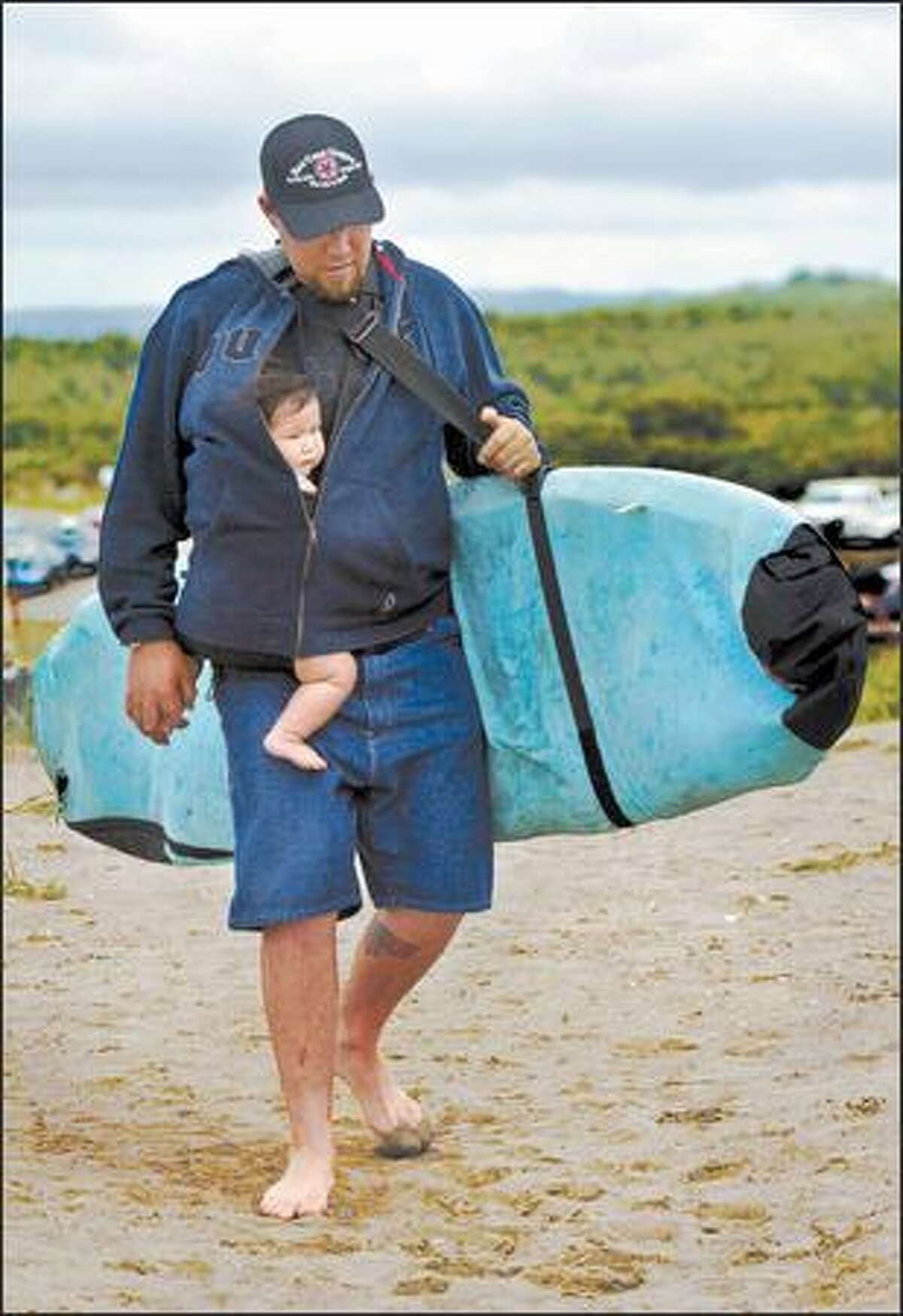 Marcel Peterson of McLeary brings his 8-month-old daughter, Jasai, to the beach during the Clean Water Classic in Westport on May 13.