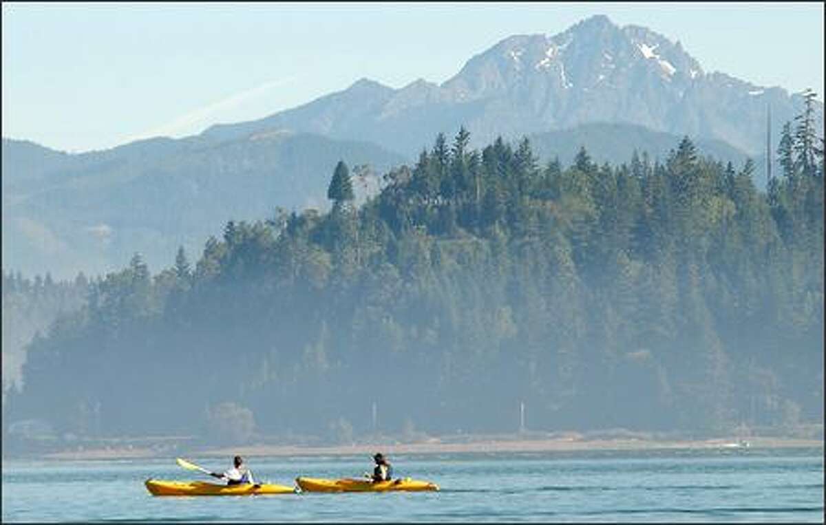 Kayakers cruise the placid waters of Hood Canal near Alderbrook Resort and Spa.