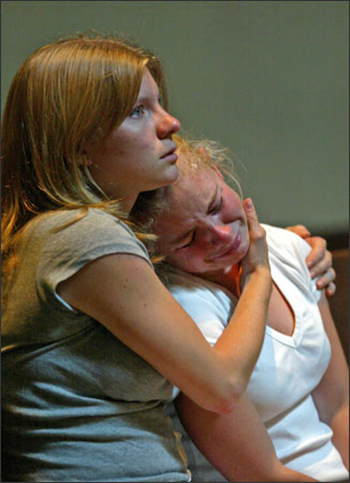 During a mass at St. James Cathedral, 21-year-old Sarah Estill, left, comforts her 17-year-old sister, Jenny, both of Seattle. They were affected by the prayers for the victims of the July 7 bombings in London, which killed more than 50 people. Sarah, recently returned from England, said she was glad it wasn't bigger, while Jenny remarked, "THis stupid war."