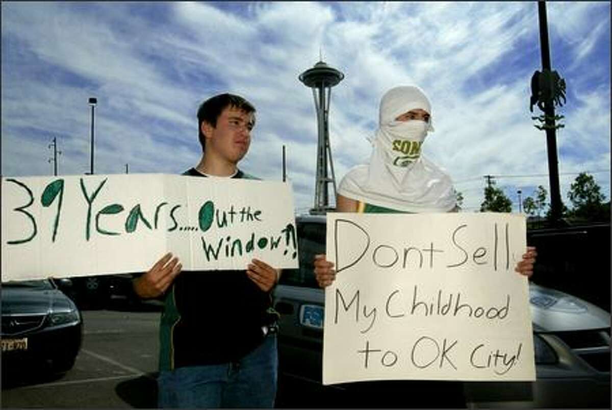 Aaron Morse, left, and Ben Conway, both 18 and of Seattle, make their feelings known outside the Sonics' and Storm's practice facility during Tuesday's press conference.