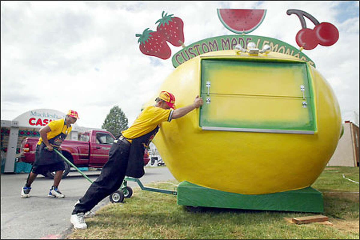 Christopher Turpin, left, and Robert Kittle of Phoenix push their lemonade stand into place at the King County Fairgrounds in Enumclaw yesterday. The fair, which officially opens today, is returning to its "old-time country" roots, say organizers, with less glitz and more family-oriented entertainment.