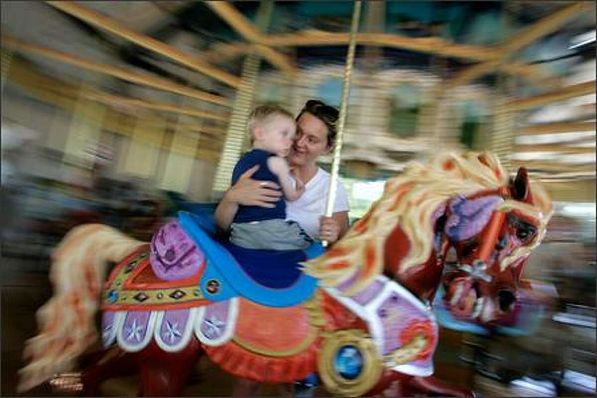 Riders on the historic carousel at Woodland Park Zoo in Seattle on Sunday included Ryan Hundren, 2, and mom Ronda of Renton. The Philadelphia Toboggan Co. built the carousel in 1918 for the Cincinnati Zoo. The carousel was a gift to Woodland Park Zoo from Linda and Tom Allen of the Alleniana Foundation, and it was opened Saturday. The pavilion and restoration cost $3.2 million.
