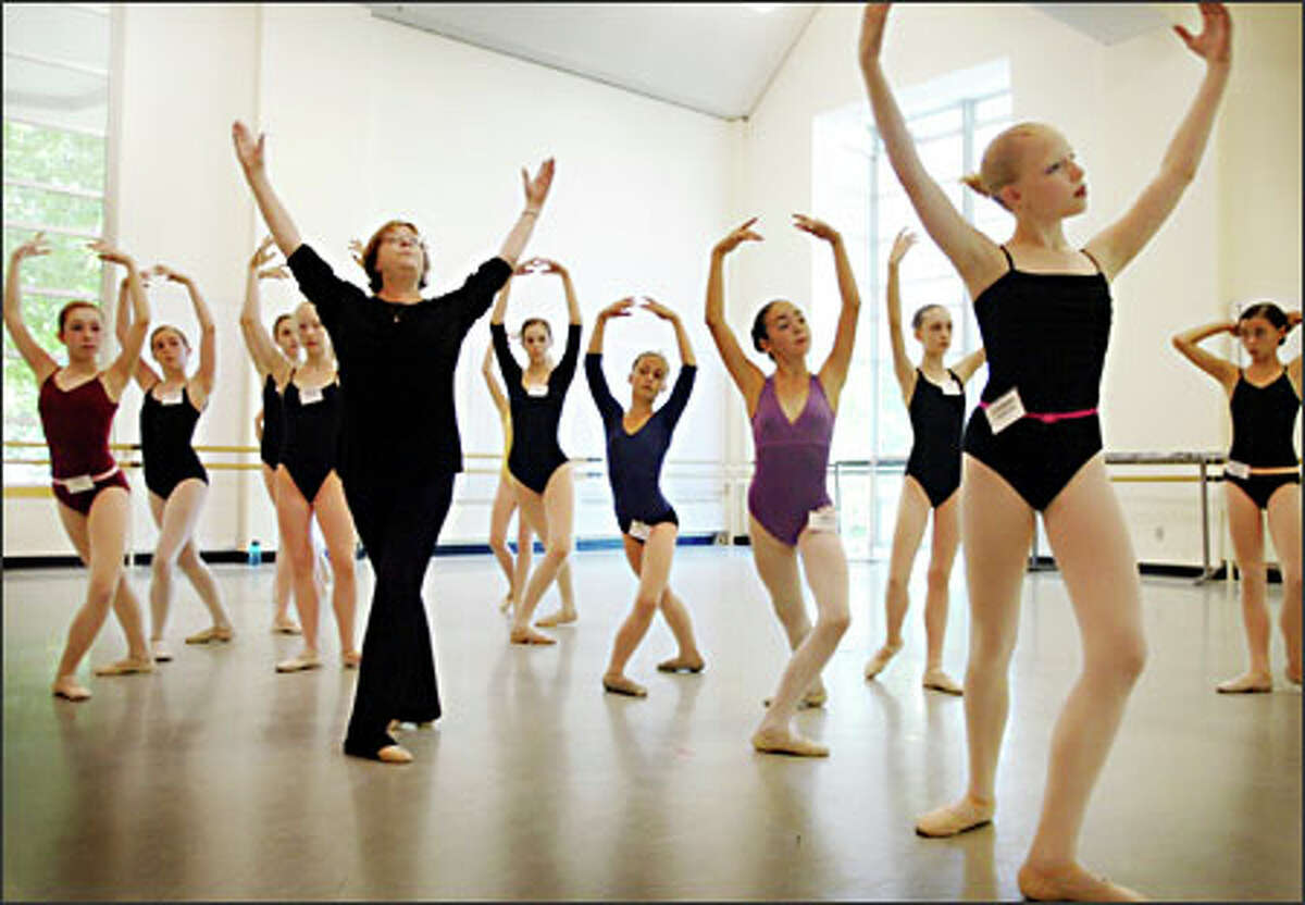 Pacific Northwest Ballet faculty member Victoria Pulkkinen works yesterday with young students, including Christina Blankenship, 12, from Minnesota, right foreground, during PNB's summer course and workshop program at its studios on Mercer Street.