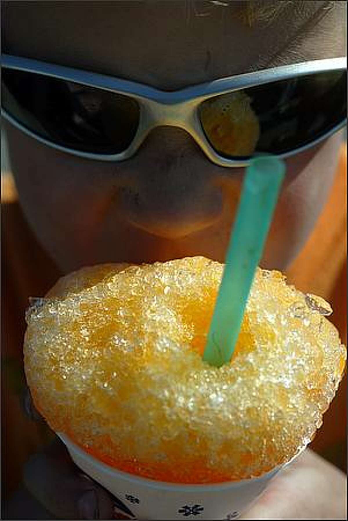 Henry Estberg, 7, slurps a sno-cone to keep cool. Temperatures are expected to reach 90 degrees today.