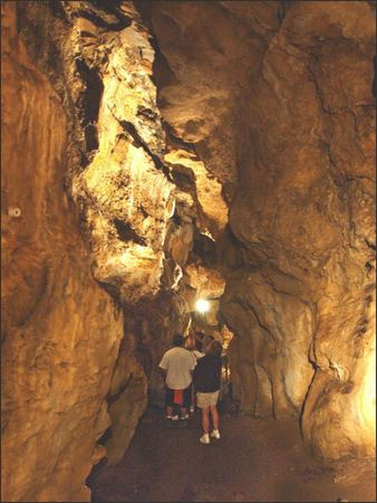 Visitors move through the bowels of Gardner Cave in Crawford State Park. The limestone cave is the third longest in Washington.