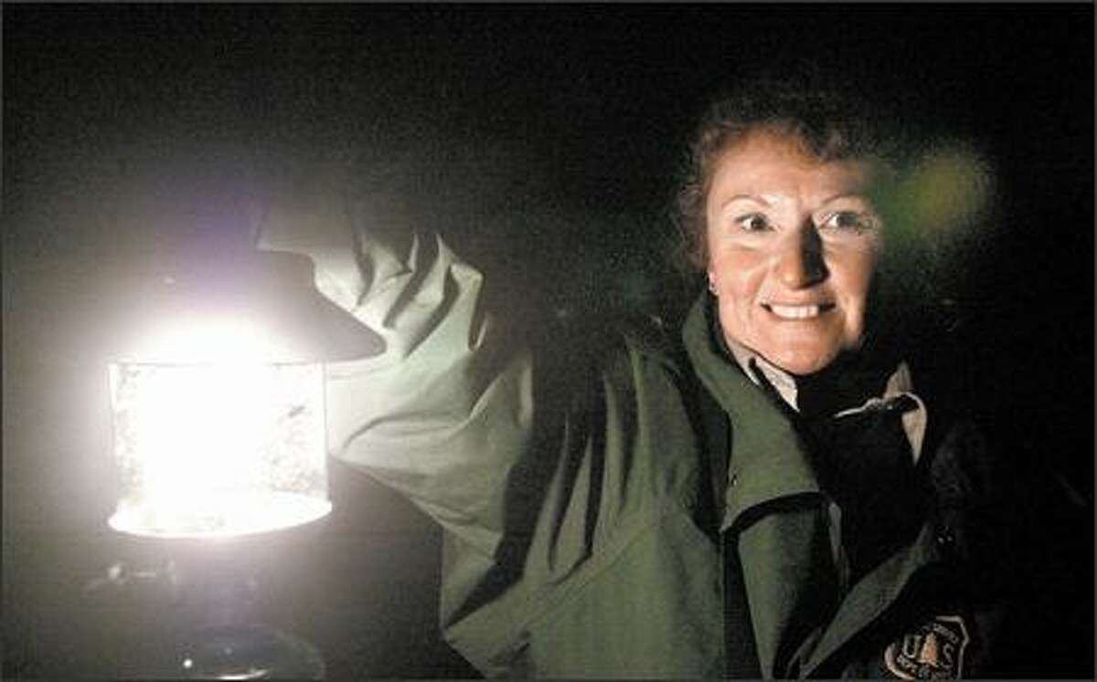 Debra Highsmith, a volunteer ranger with the U.S. Forest Service, lights the way with her lantern as she leads a tour of Ape Cave.