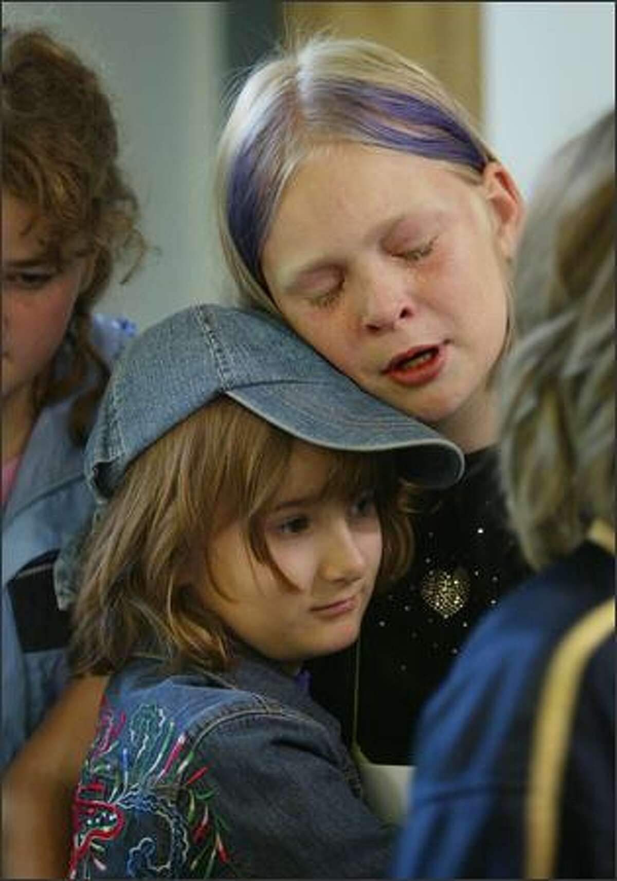 Teary-eyed over the news that Seattle's Alternative School No. 1 has been targeted for closure, Becca Mussman, a fifth-grader, hugs third-grader Ellie Preston.