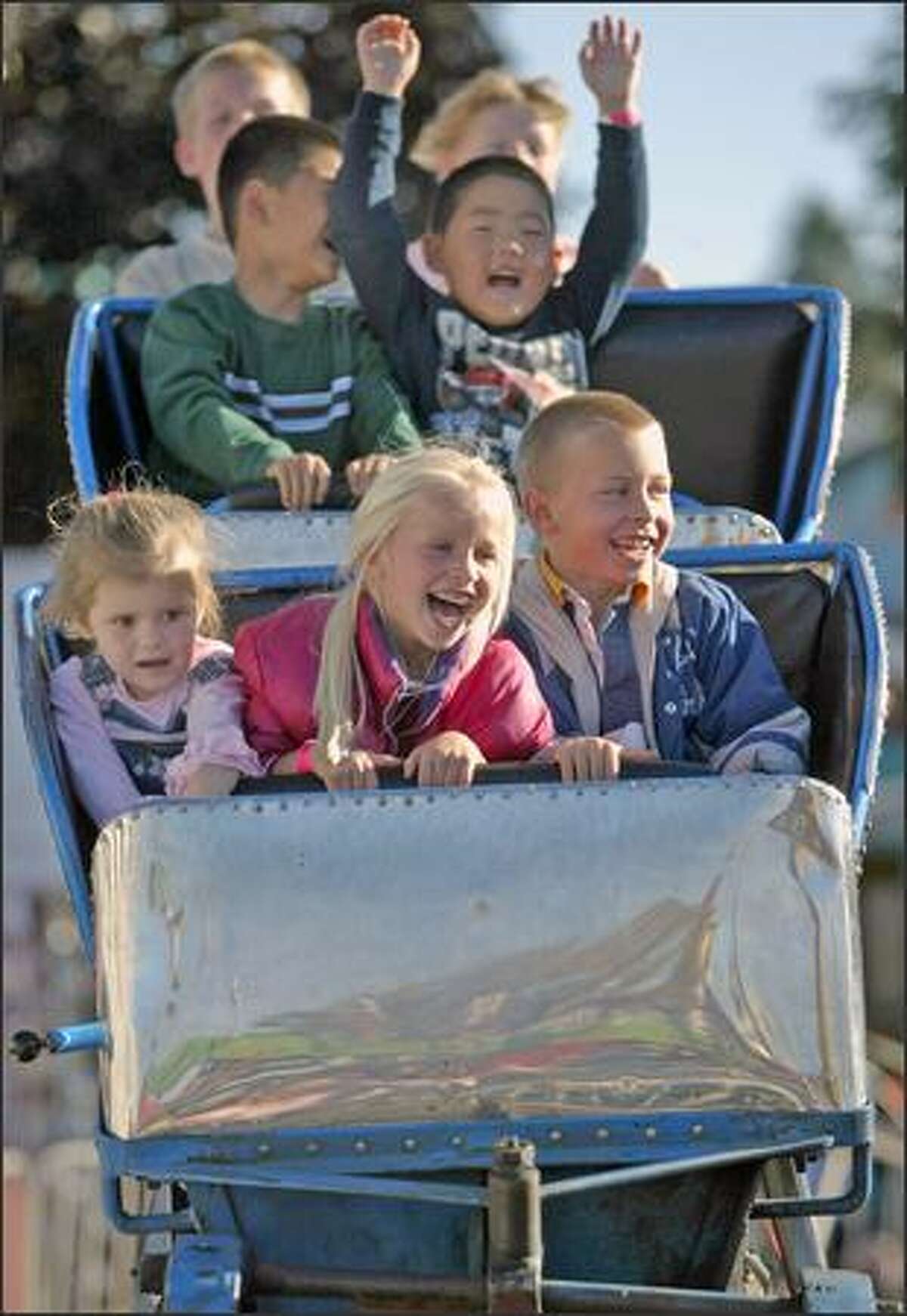 From left, Luccia Buck, 3, Abby Leaman 5, and Noah Leaman, 6, ride the little people's roller coaster at the Puyallup Fair earlier this week.