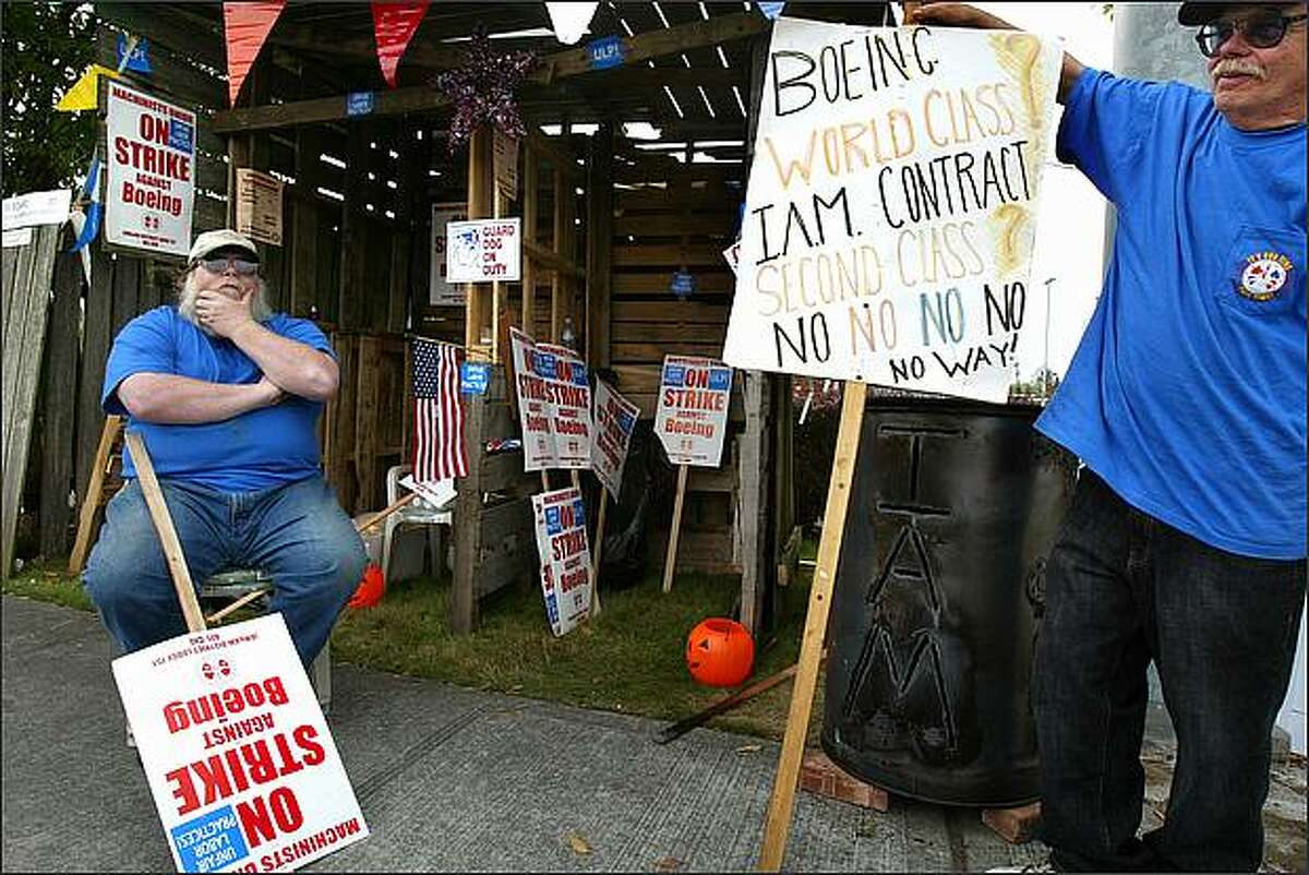 Terry Moore (left), a plant maintenance employee, and James Carey, a crane mechanic for Boeing for 35 years, protest outside a Boeing plant in Renton on Tuesday, Sept. 23. Moore wants better medical coverage while Carey believes the company should keep the jobs in America. (Karen Ducey/Seattle P-I)