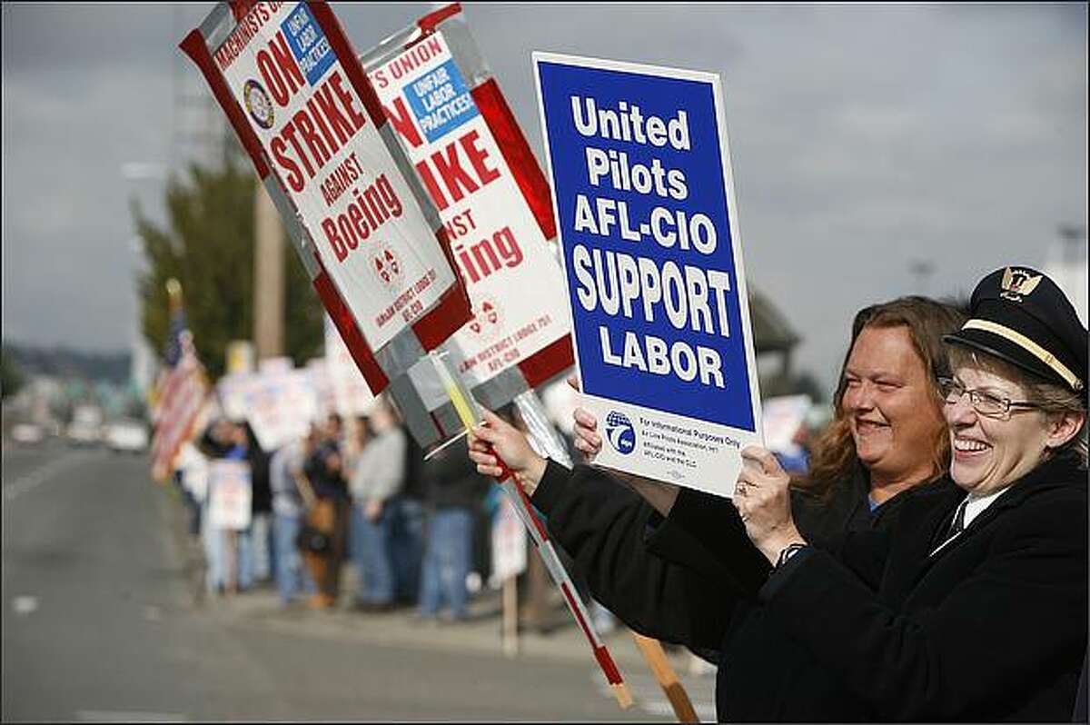 Cindy Reverstein, United Airlines first officer, right, joined Deanna Groom, a 10-year machinist from the Boeing Renton plant, as Reverstein and other union airlines employees joined striking Boeing machinists on the picket line at Gate 39 at Boeing Field on Thursday, October 9, 2008. (Paul Joseph Brown/Seattle P-I)