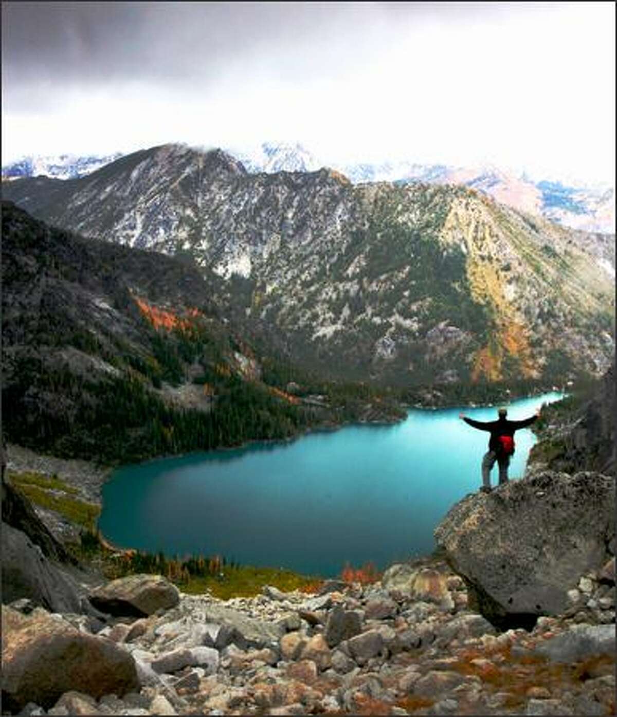 A hiker takes in the sights of Colchuck Lake from the top of Aasgard Pass on the way to Enchantment Lakes Basin.