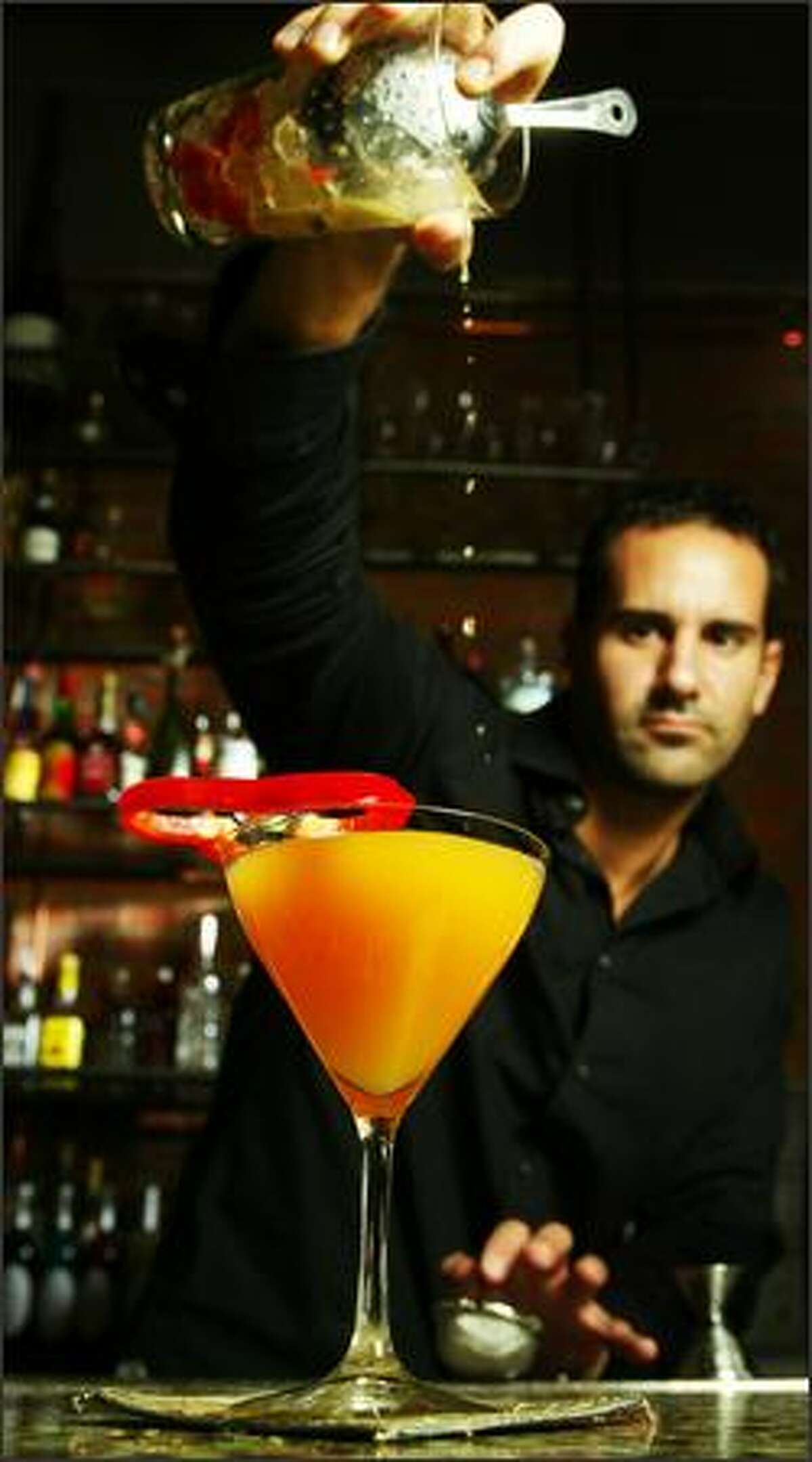 Mixologist Ryan Magarian, whose consulting company is called Liquid Kitchen, pours a cocktail at Kathy Casey Food Studios.