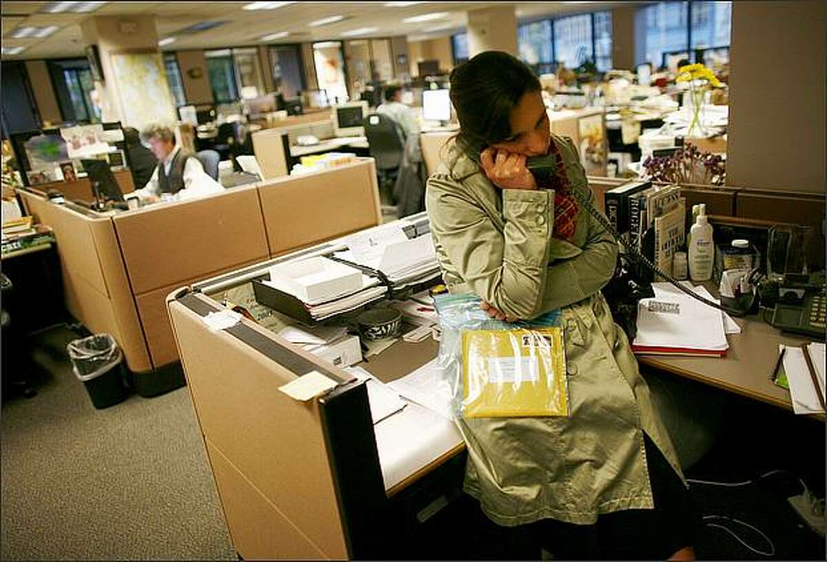 Breaking news editor Candace Heckman speaks on the phone as she holds a package labeled "anthrax" at the Seattle Post-Intelligencer newspaper. The package was opened by Heckman and contained a disk with an image of Colin Powell and a packet with a powdery substance.