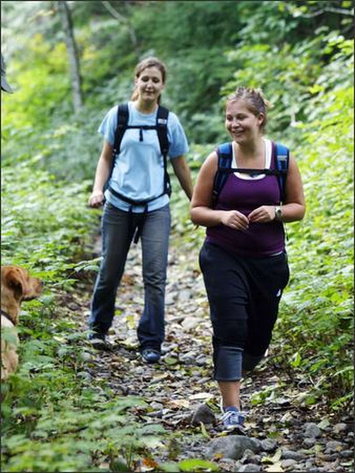 Hikers Shannon Thorsen, left, and Cassie Adams, both of Seattle, amble along the Taylor River Trail, an abandoned logging road.
