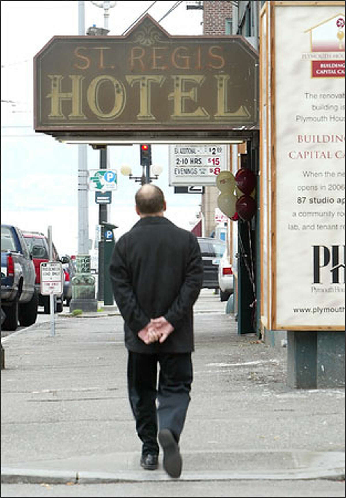 A pedestrian strolls past the old St. Regis Hotel at Second and Stewart in downtown Seattle.