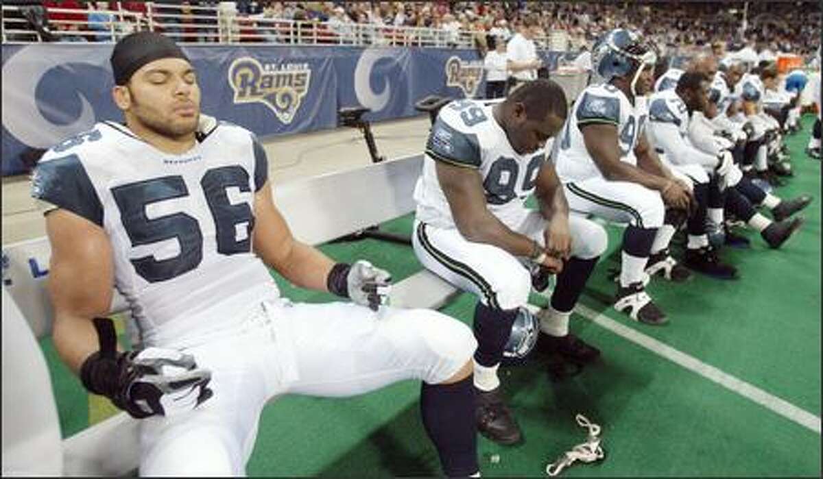 Seahawks defensive end Chike Okeafor (56) meditates on the bench as time expires.