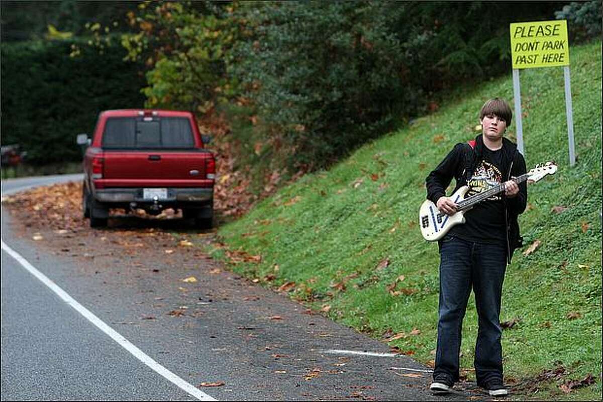 Wolfgang Olson, 13, plays his bass guitar as he waits for the school bus in Lake Forest Park. Olson is a seventh grader at Room Nine Community School.