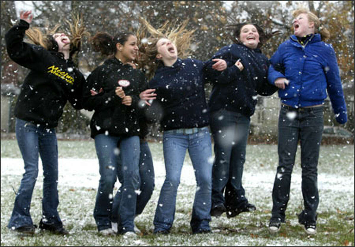 From left, Samantha Weyer, 14; Theresa Barnes, 13;, Torey Perfect, 13; Sarah Bach, 14; and Vanessa Burke, 14, leap as they try to catch snowflakes on their tongues at the Queen Anne Playfield as the white stuff made a rare visit to Seattle. Some McClure Middle School students were let out of class and gathered in the park to enjoy the weather.