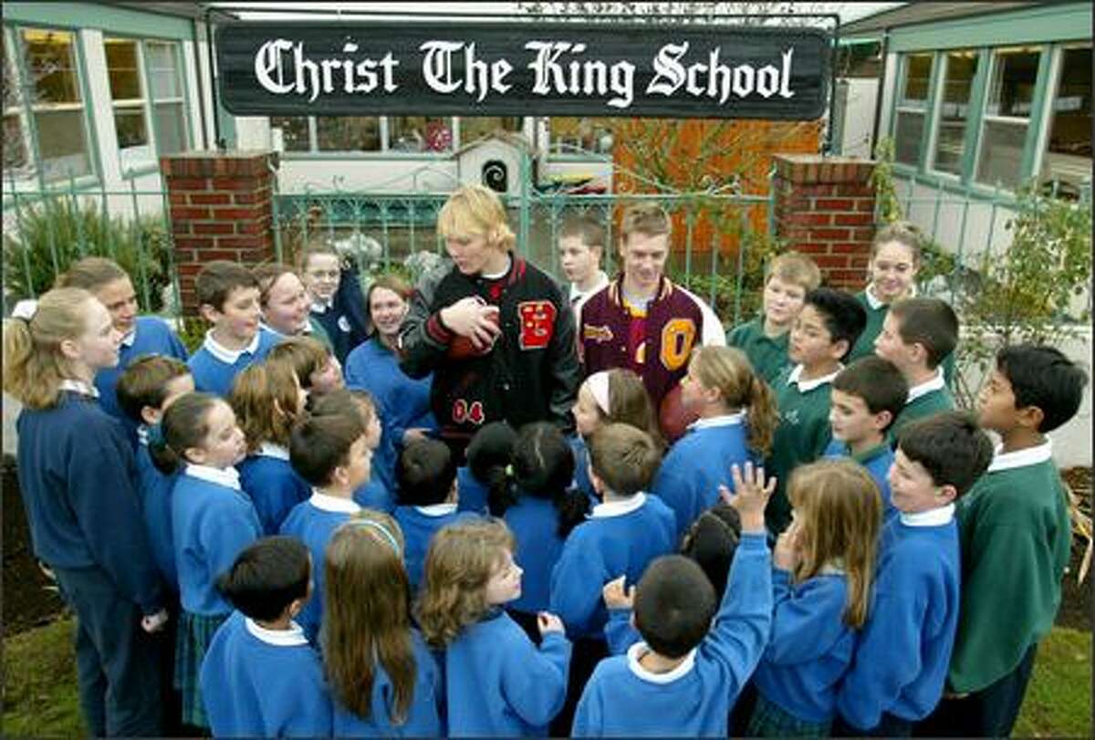 Quarterbacks Cole Morgan from Ballard, left, and Joey Shanks of O'Dea meet with students at Christ the King School, where the football players were once schoolmates.