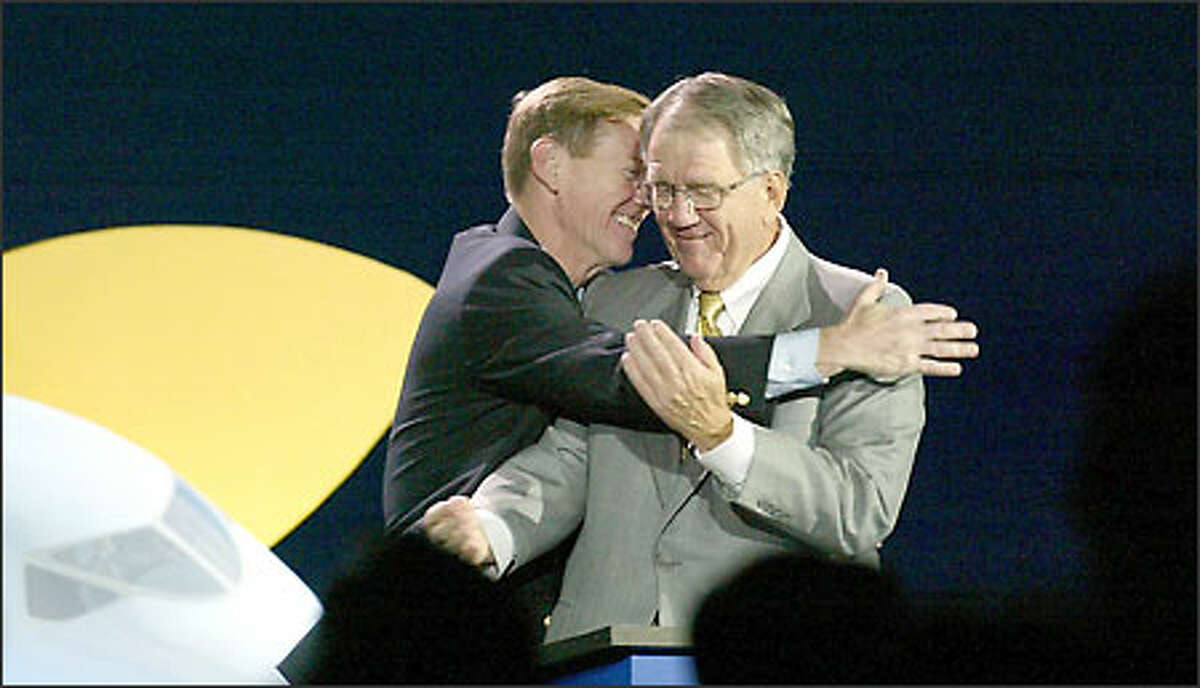 Boeing commercial airplane President Alan Mulally, left, embraces Chief Executive Officer Harry Stonecipher at the convention center, where thousands gathered for the 7E7 announcement.