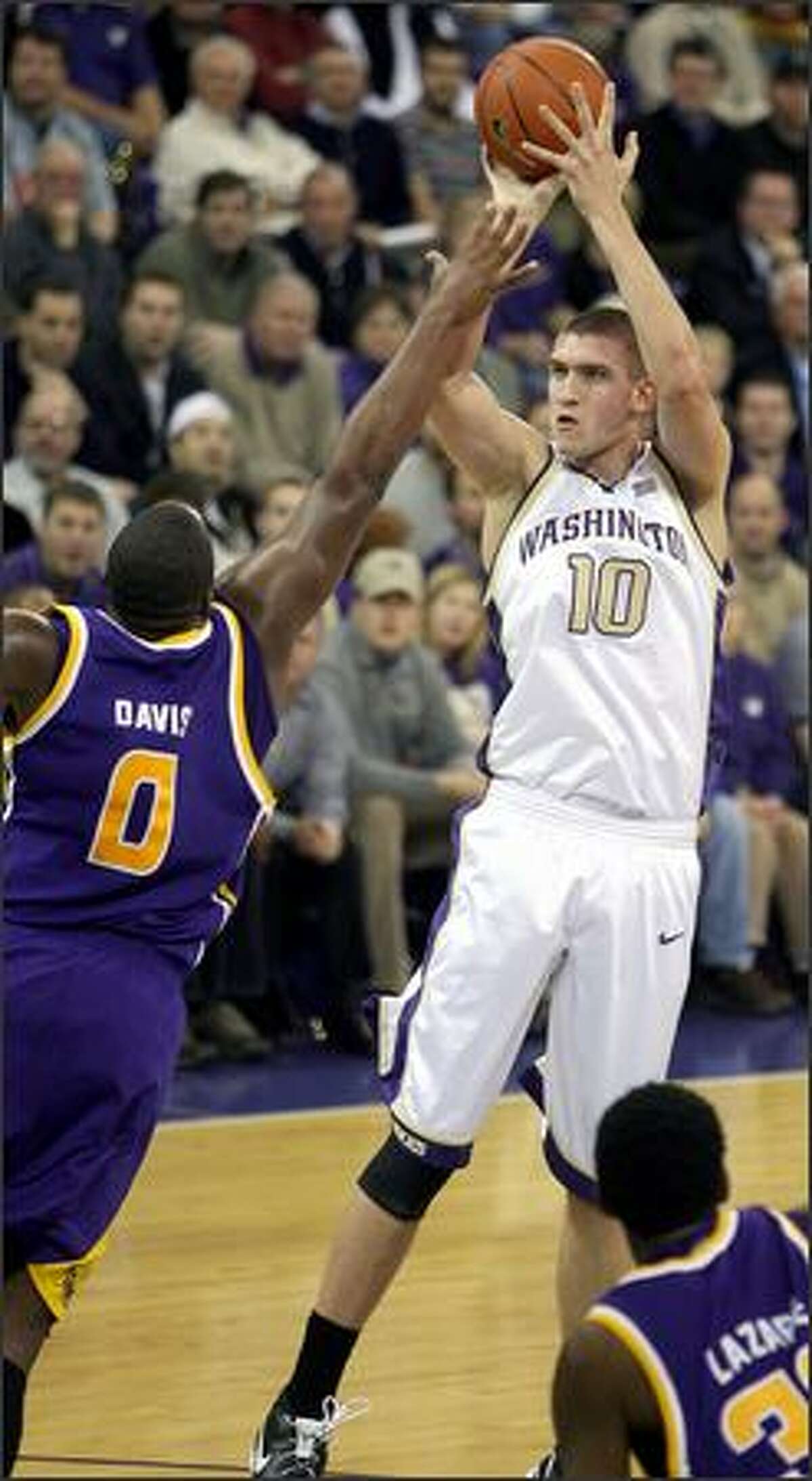Washington's Spencer Hawes shoots and scores over LSU's Glen Davis during the first half of Wednesday's game. Hawes scored 23 points as the Huskies pulled a 88-72 upset.