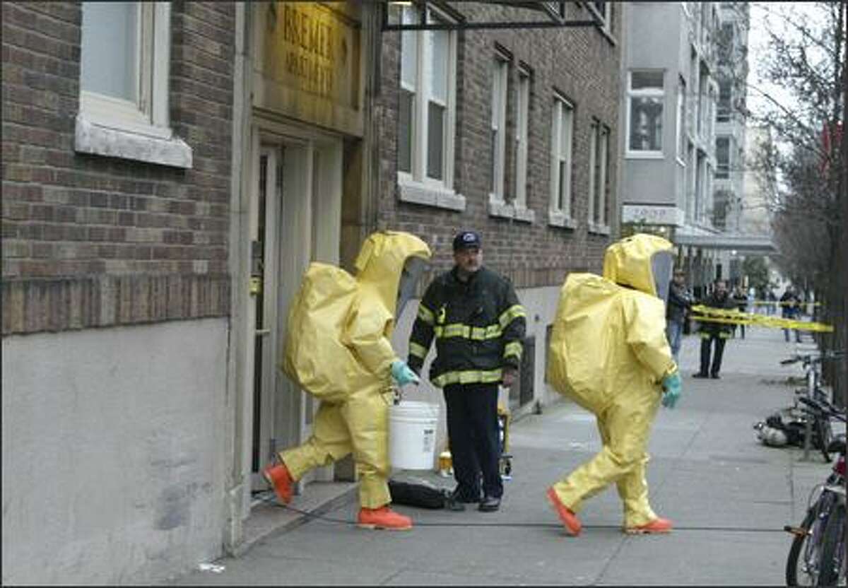 Members of the Seattle Fire Department's hazardous materials team leave the apartment at the corner of First Avenue and Broad Street. Authorities investigated a suspected meth lab after residents in the building reported a noxious smell. Nothing toxic was found.