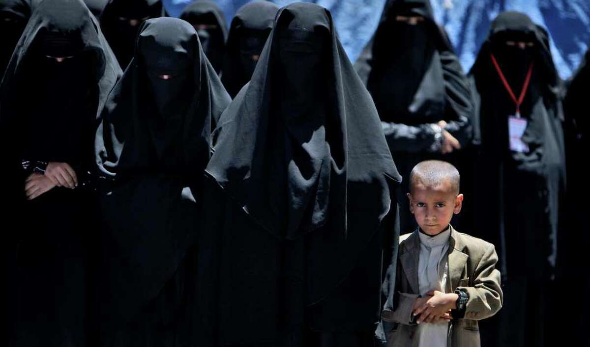A Yemeni boy, right, looks on while praying with female anti-government protestors during a demonstration demanding the resignation of Yemeni President Ali Abdullah Saleh, in Sanaa, Yemen, Monday, April 4, 2011. Yemeni troops opened fire on crowds of protesters demanding the ouster of President Ali Abdullah Saleh, killing six and wounding more than 30 on Monday in the second straight day of clashes in a southern city, witnesses and medical officials said. The bloodshed in the city of Taiz further stoked the more than month-old uprising against Saleh's 32-year-rule. The opposition has been holding continual protest camps in main squares of cities around the country, and on Monday new demonstrations in solidarity with the Taiz protesters erupted in several places. (AP Photo/Muhammed Muheisen)