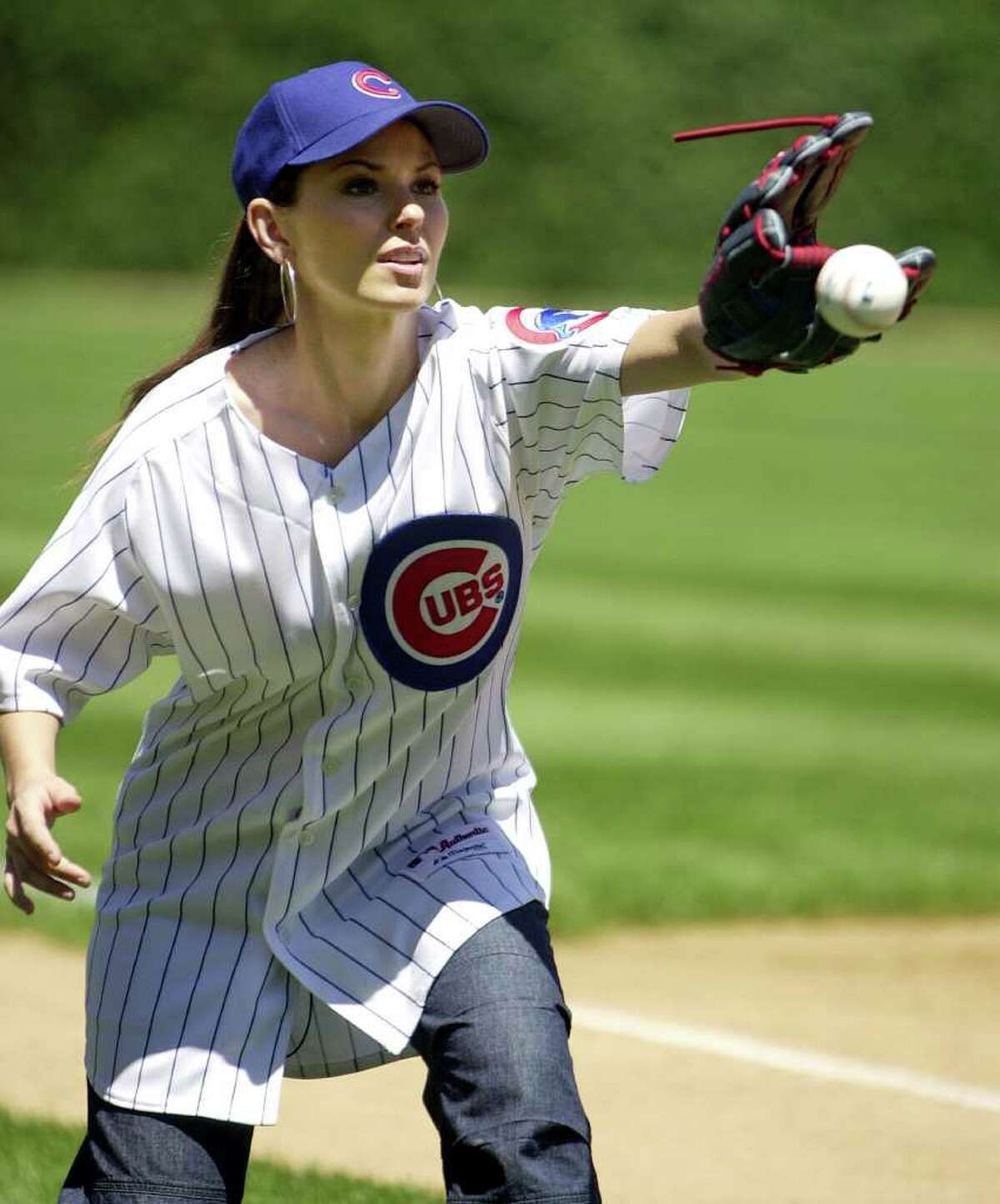 Singer Shania Twain warms up to throw out the ceremonial first pitch of the Chicago Cubs-Philadelphia Phillies game at Wrigley Field in Chicago, Thursday, July 24, 2003